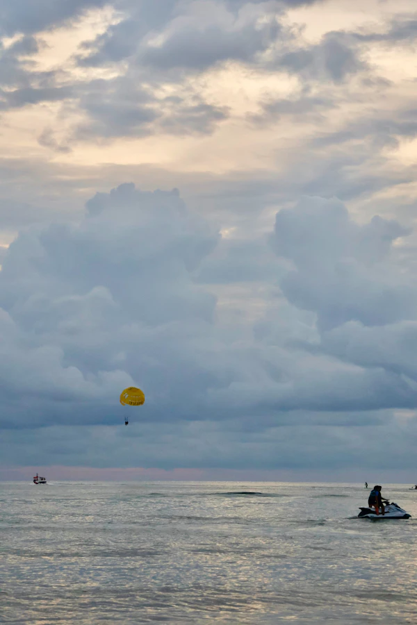 Parasailer silhouetted at dusk over the sea