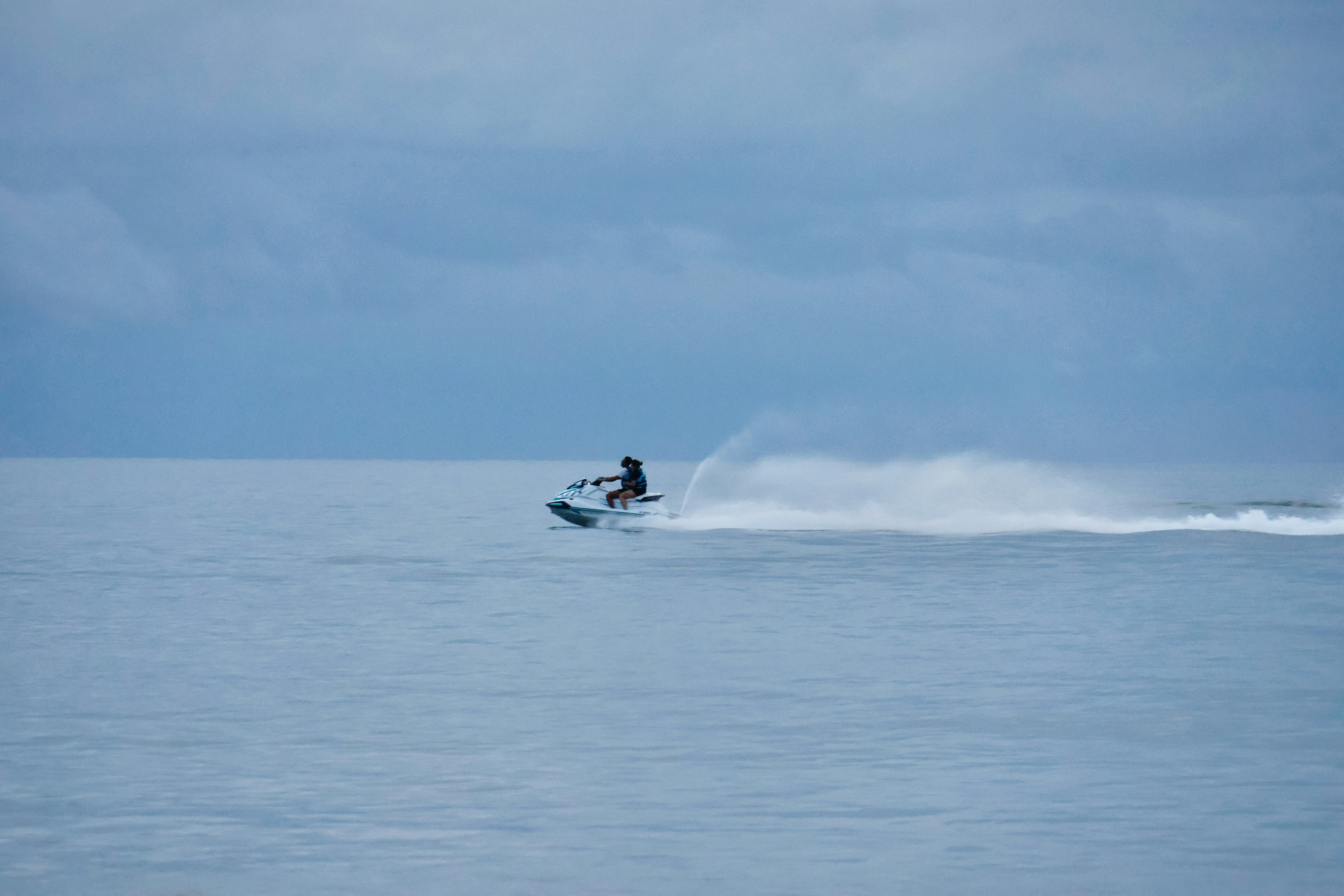 A person riding a jet ski on a calm sea.
