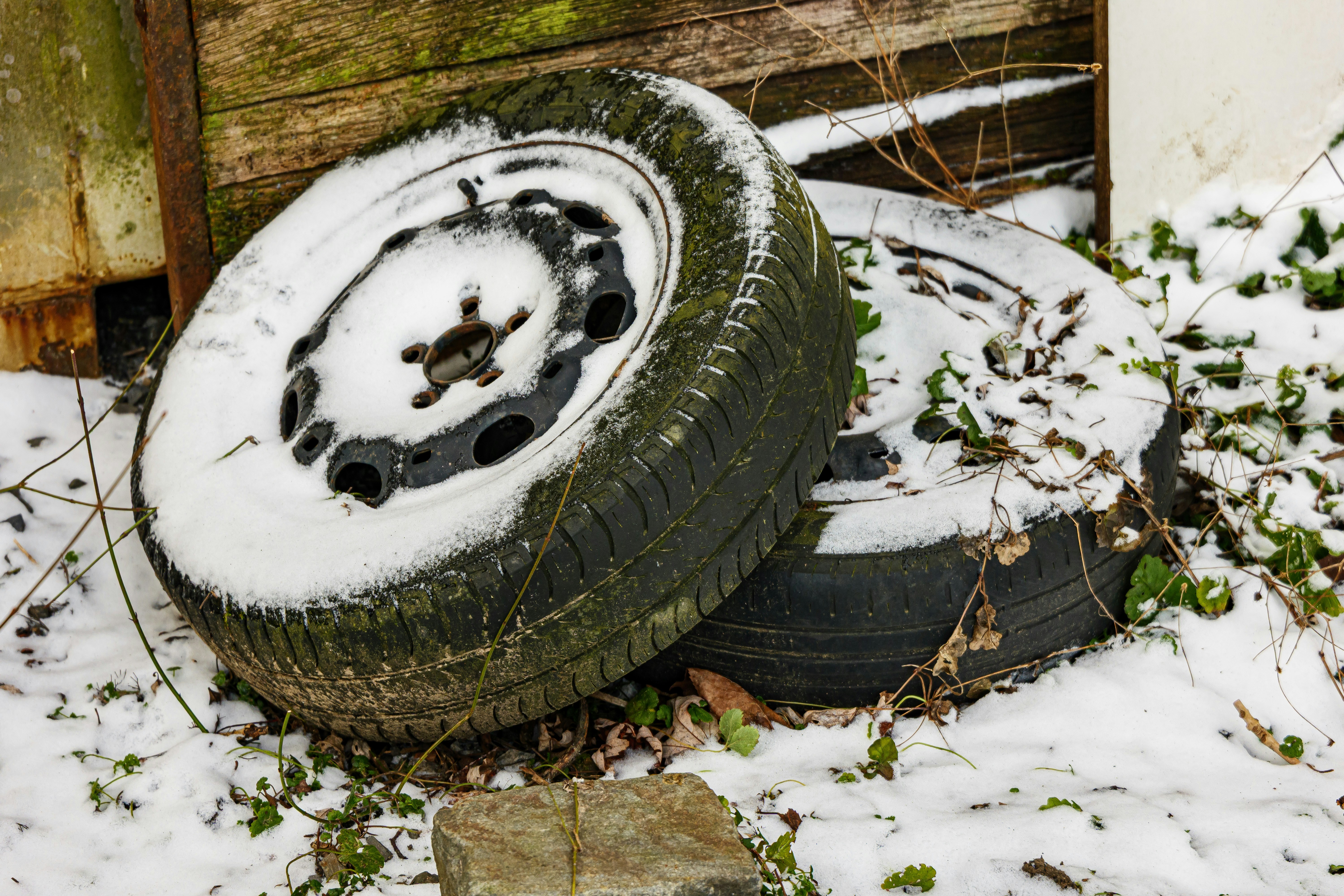 Two old tires covered in snow outdoors.