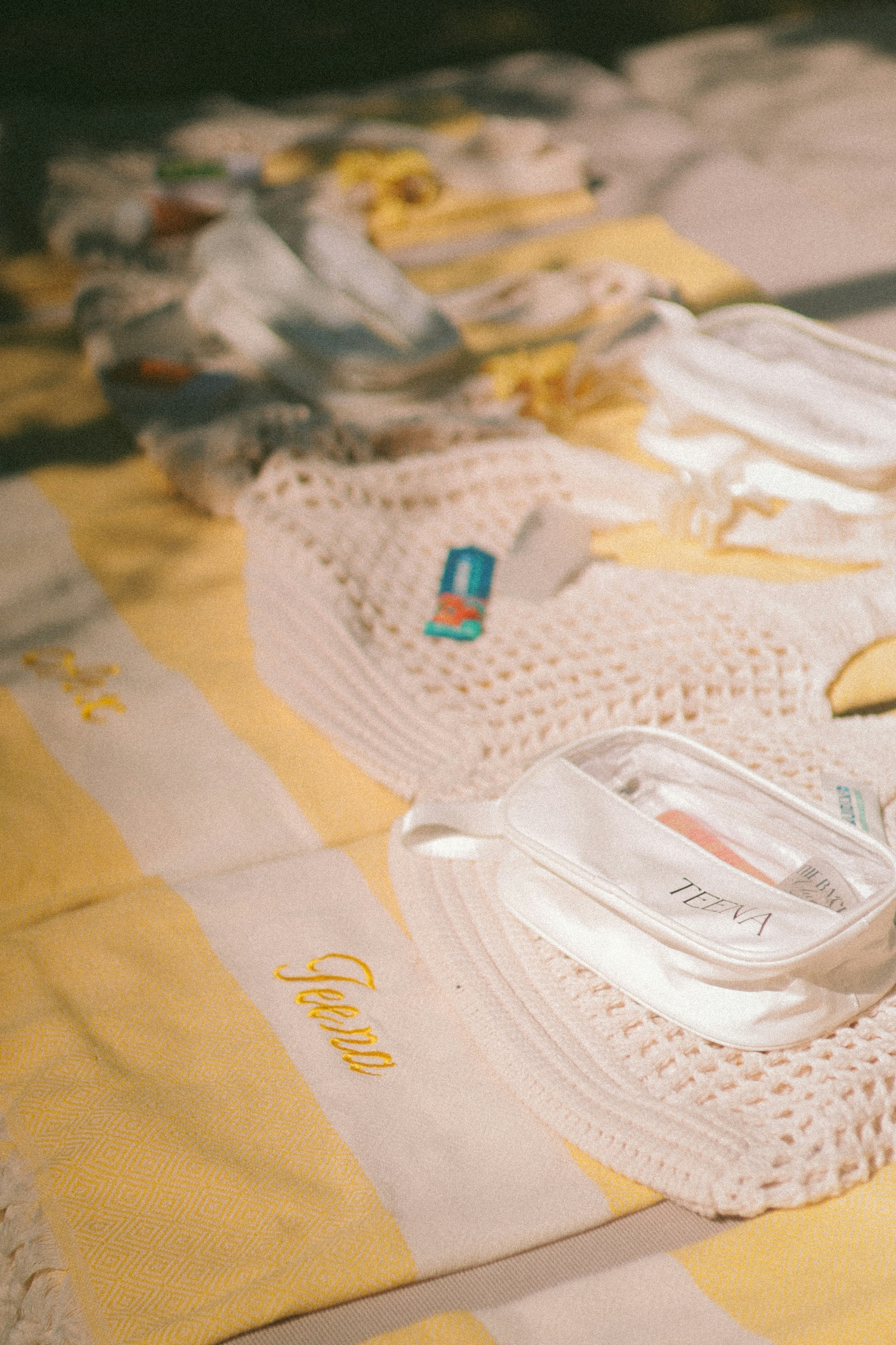 Serviette rayée jaune avec articles de toilette et sac à crochet.