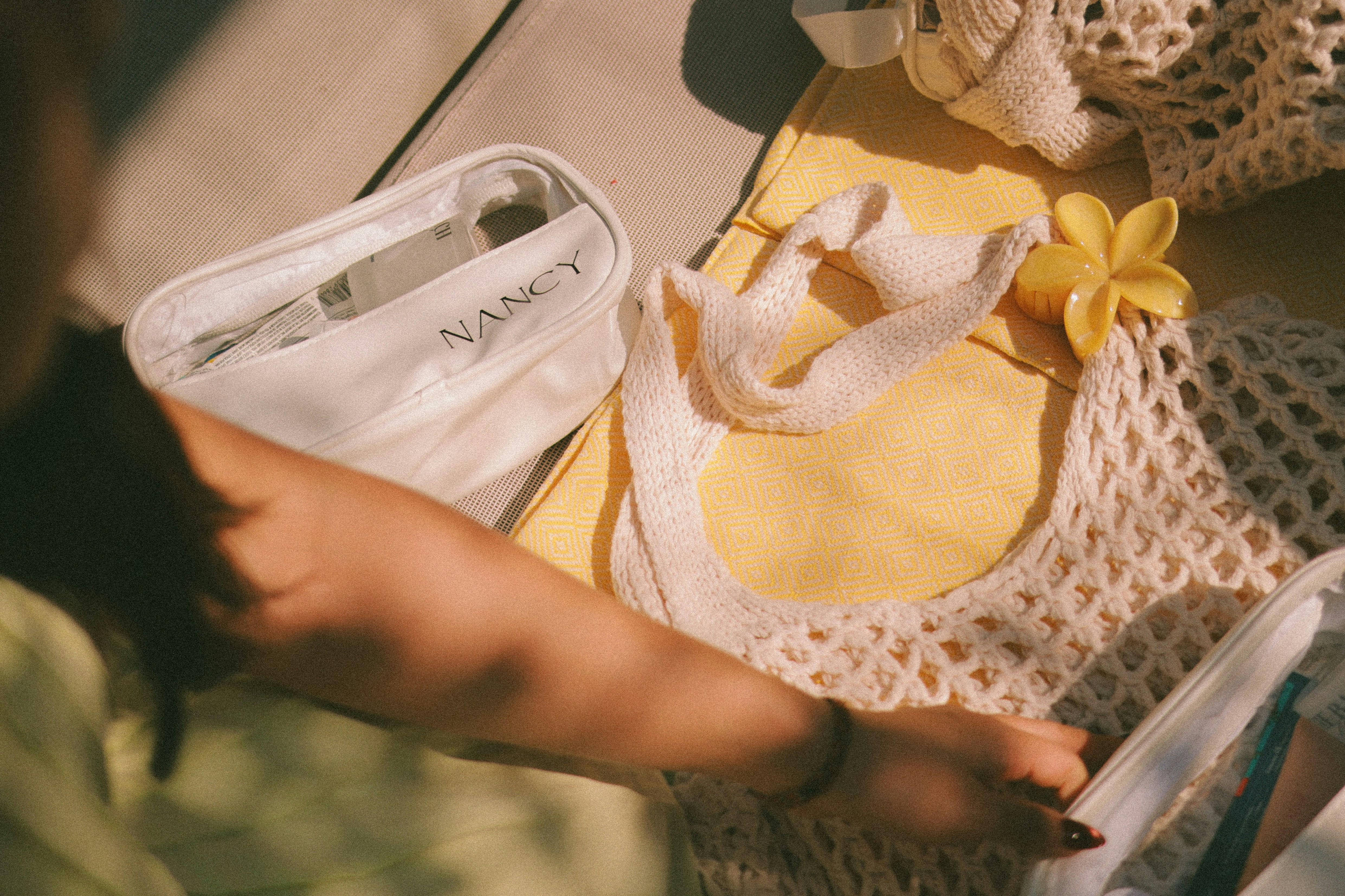 A person packing a mesh bag with items.
