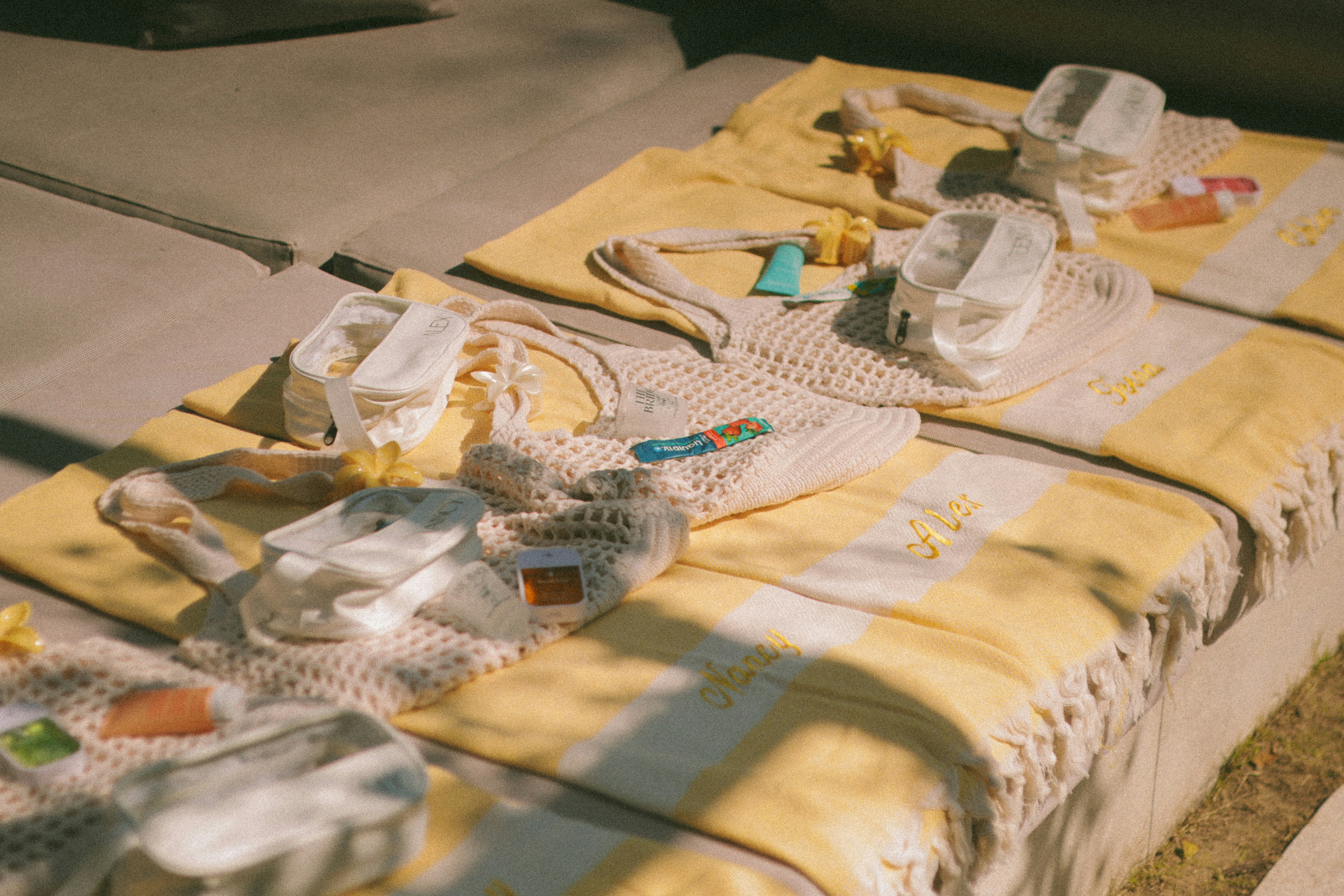 Des serviettes de plage et des sacs étalés sur des chaises longues.