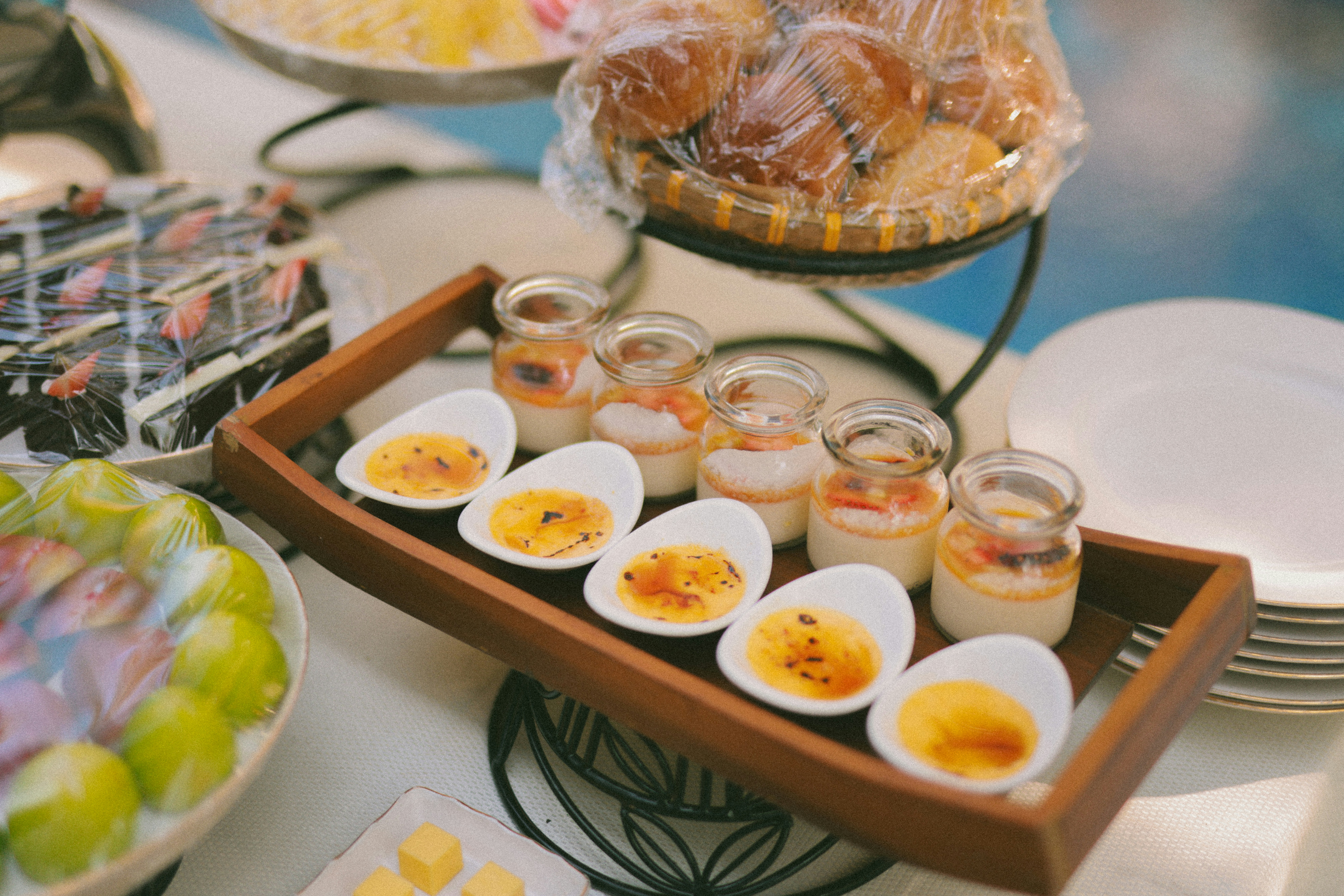 Variedade de sobremesas com pequenos potes e pratos em formato de ovo