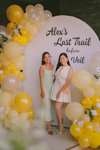 Two women at a bachelorette party with balloons.