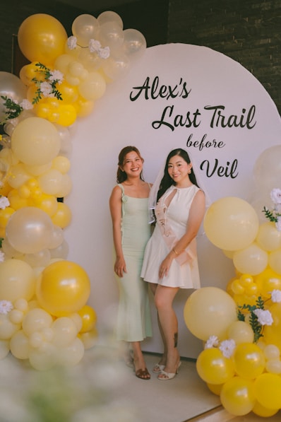 Two women at a bachelorette party with balloons.