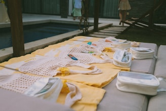 Clothes laid out on yellow blankets by a pool