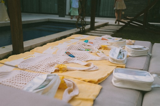 Clothes laid out on yellow blankets by a pool