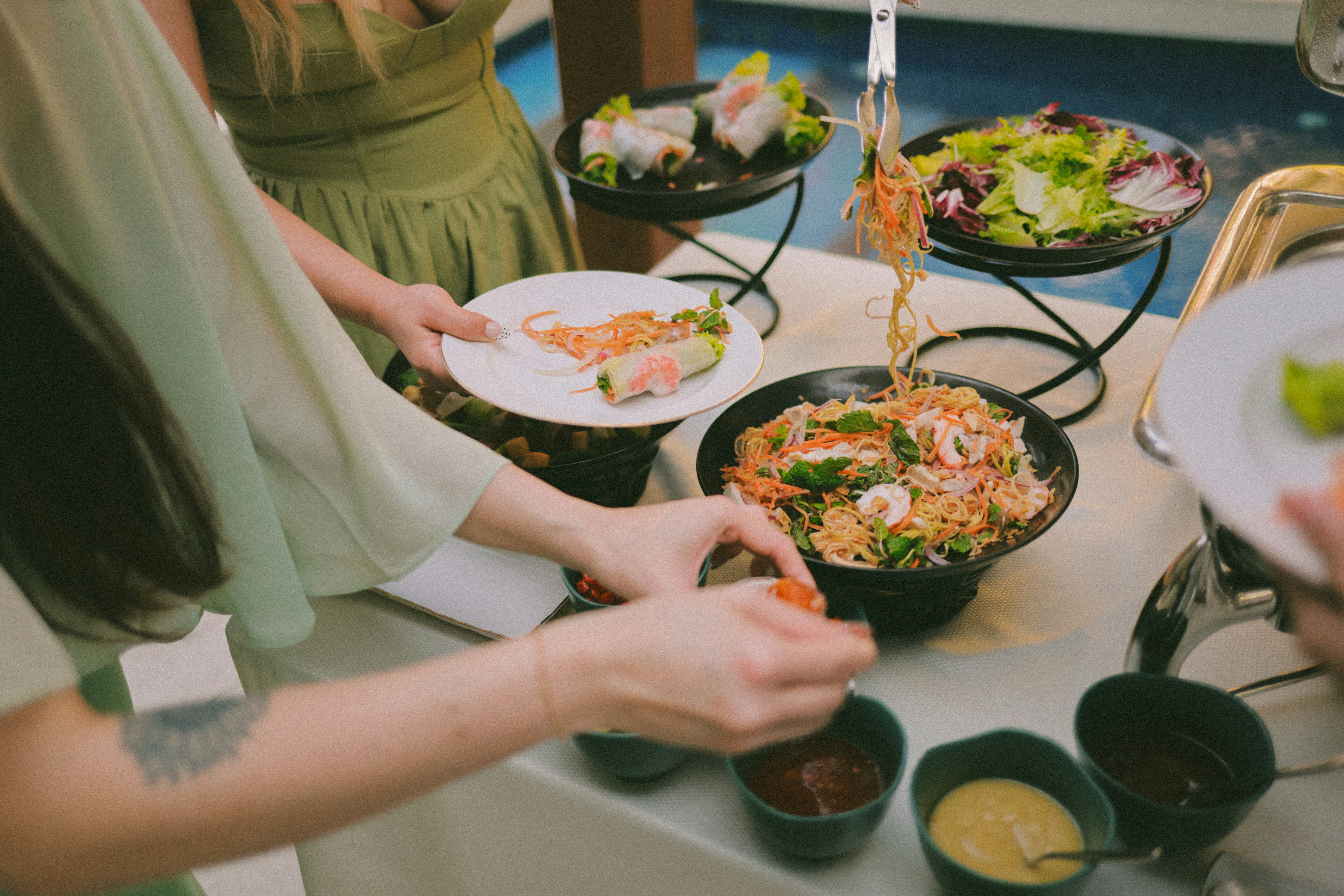 People serving food from a buffet spread