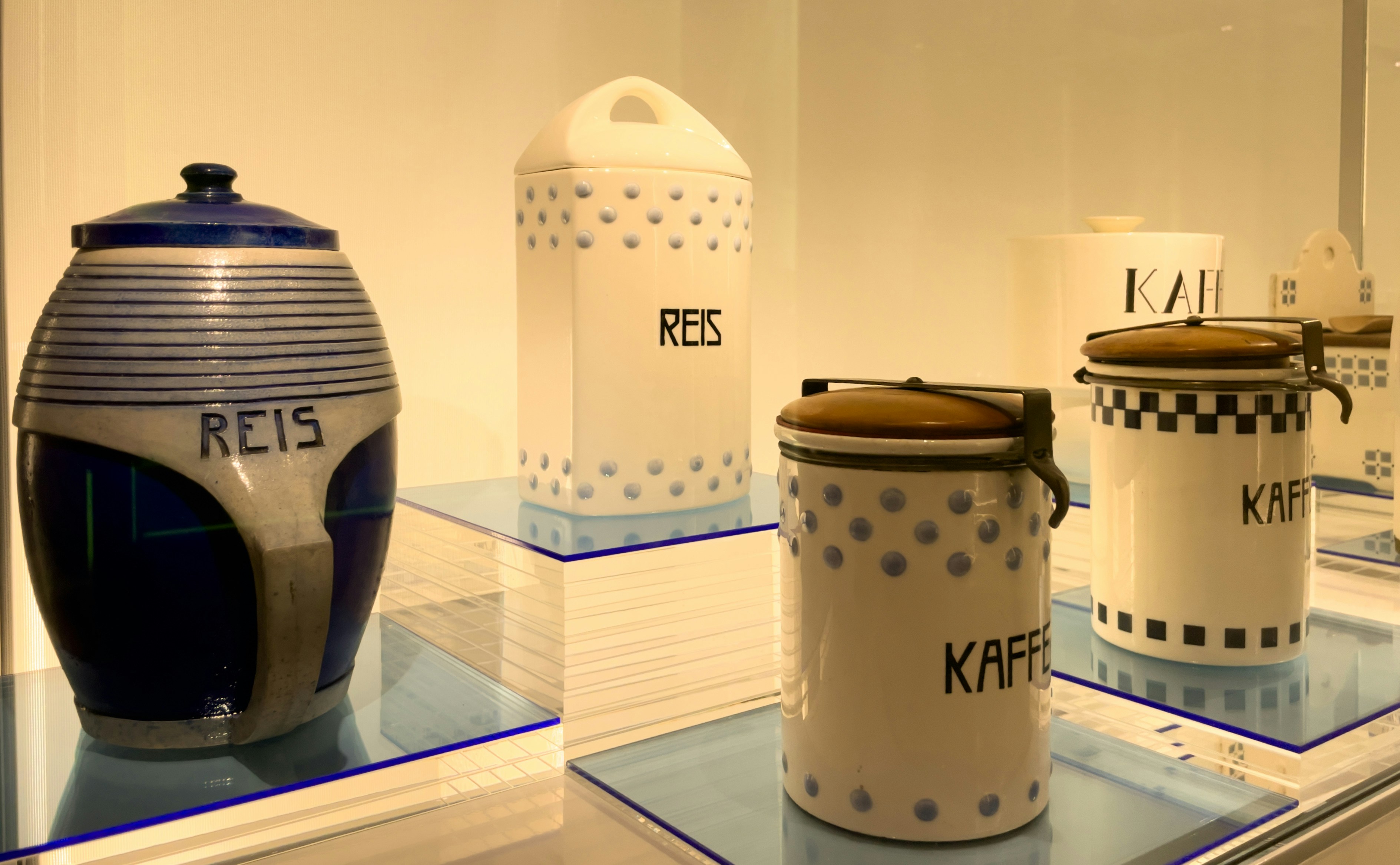 Vintage ceramic canisters labeled rice and kaffee on display