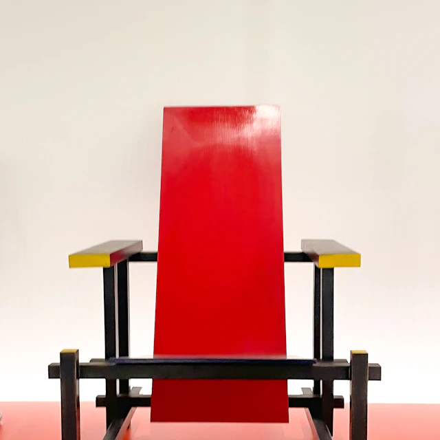 A red, black and yellow modernist chair against a white wall at the Bauhaus-Museum Weimar