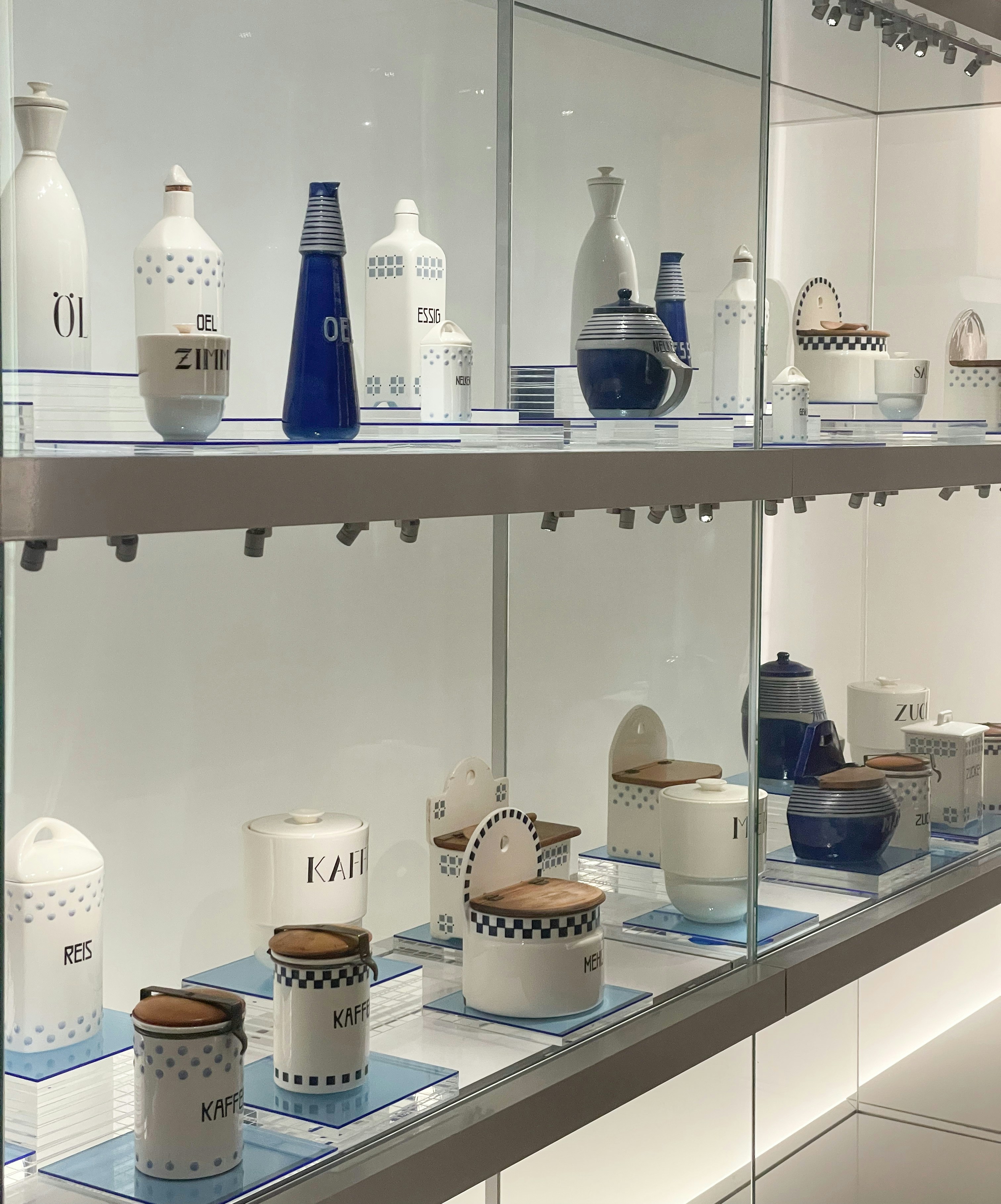 White and blue ceramic containers displayed on shelves.