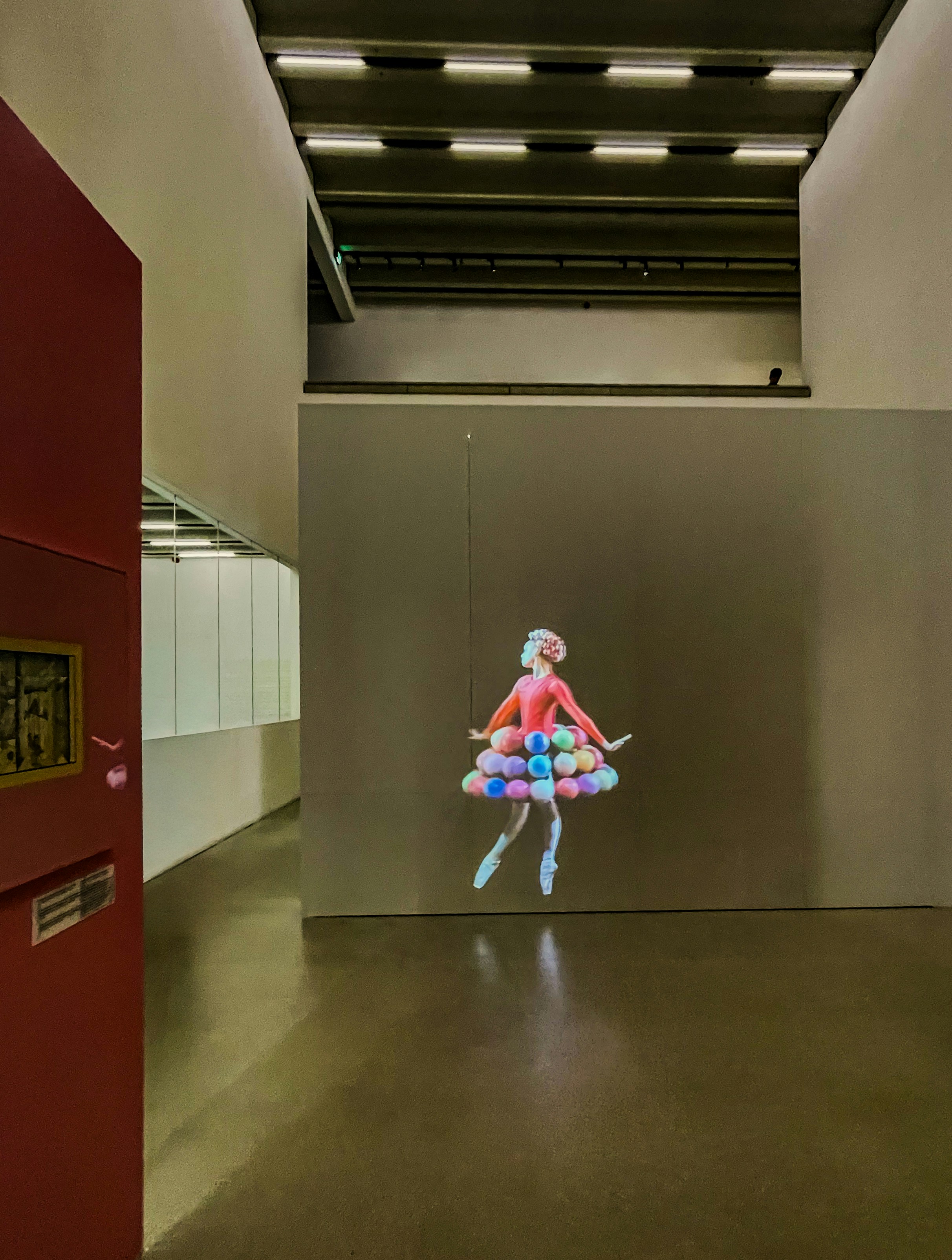 Holographic ballerina floats in a modern art gallery.