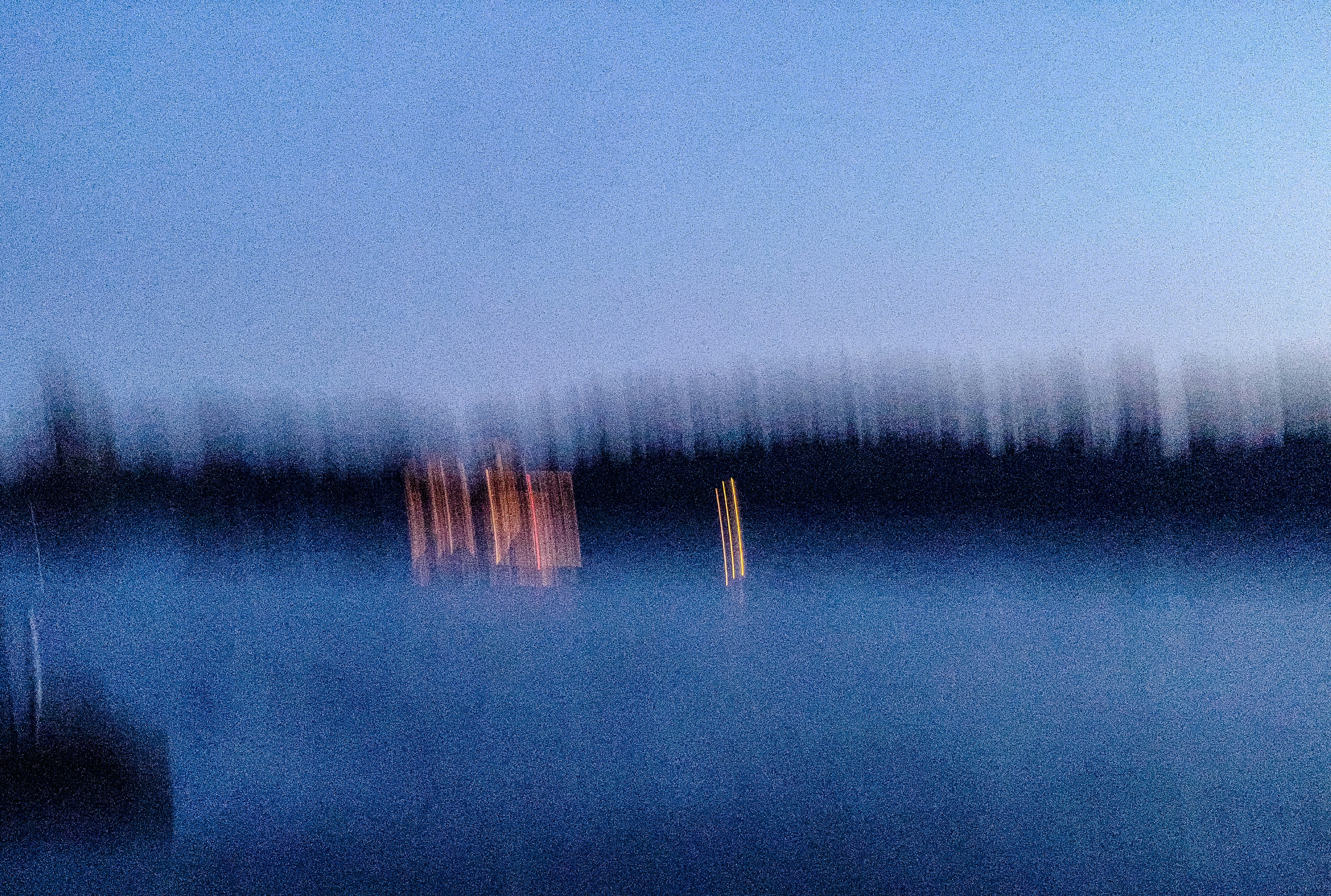 Blurred lights on a dark water surface at dusk