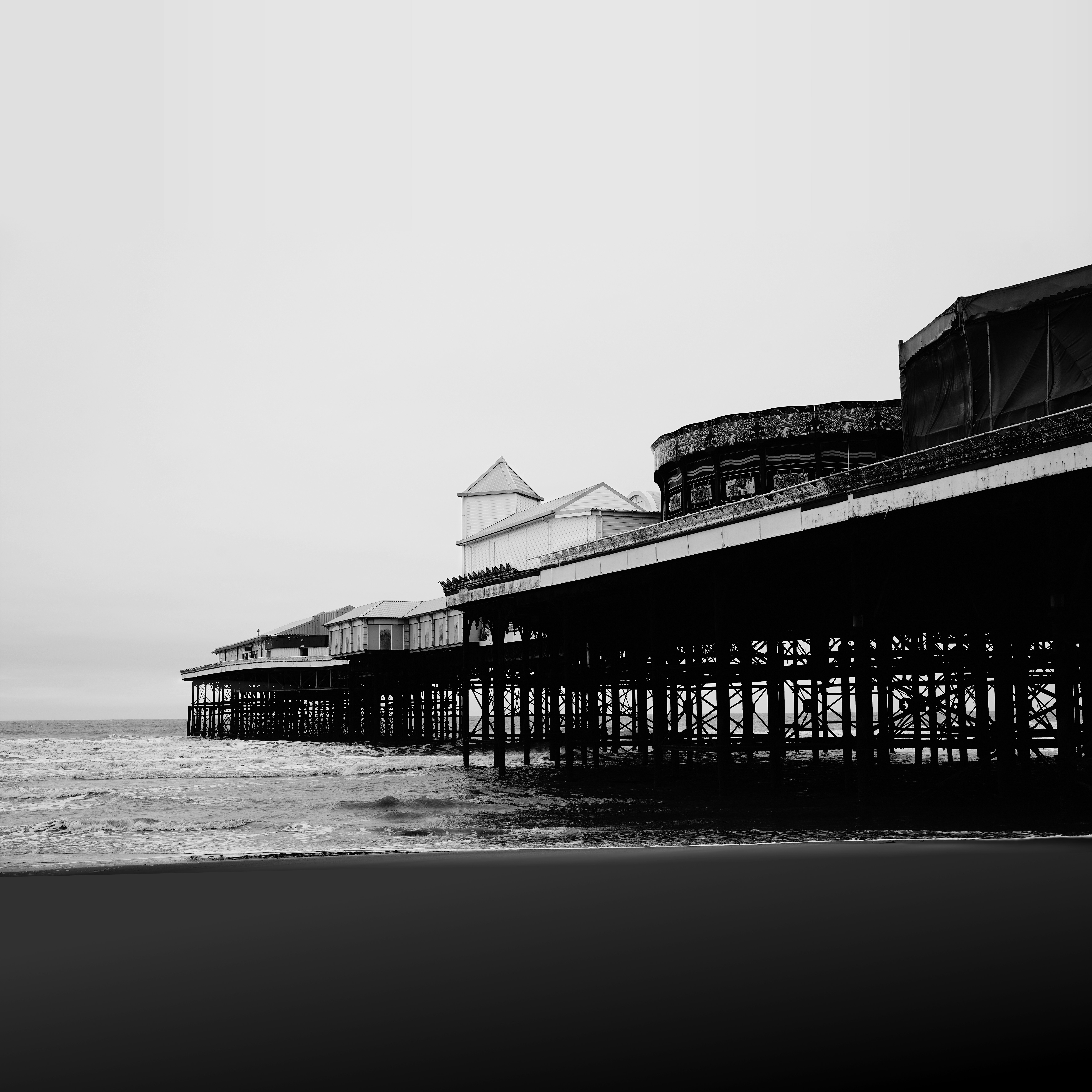 Black and white view of a seaside pier.