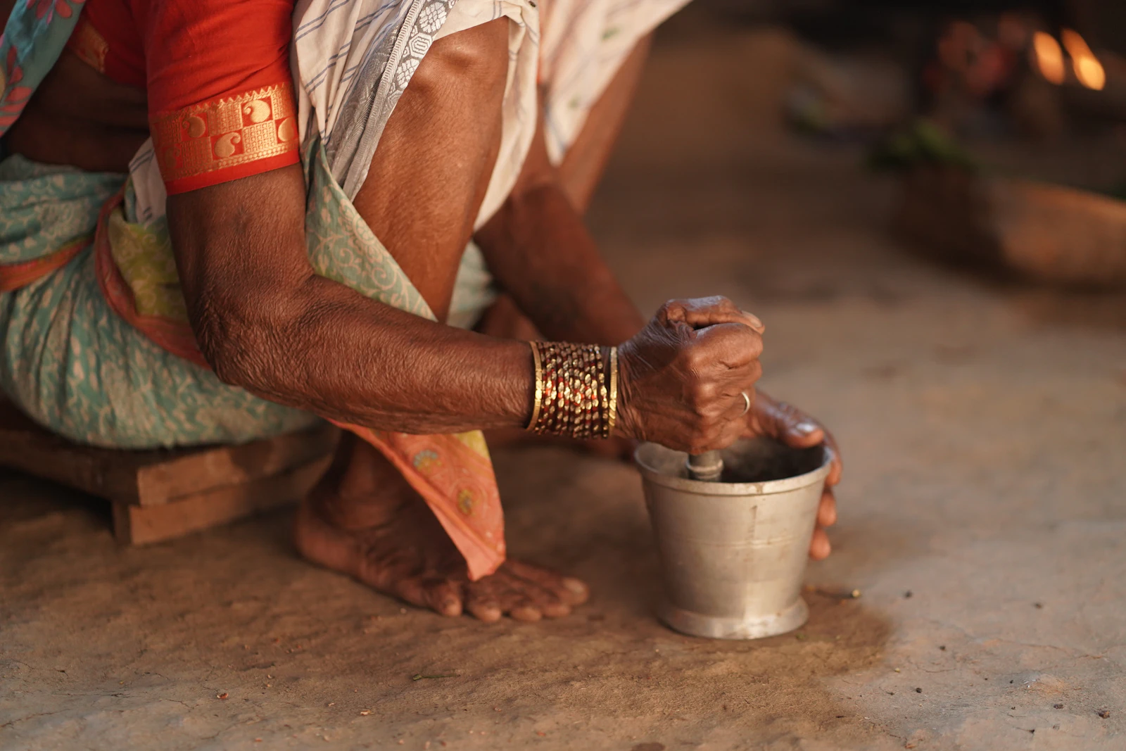 Elderly hands grinding herbs with a stone mortar and pestle in the dispensary