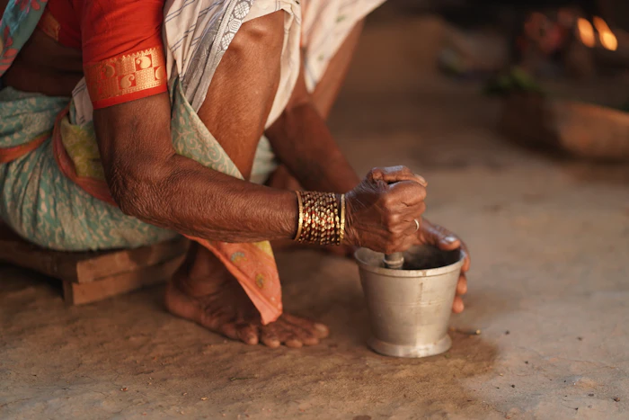 Real photo of elderly hands grinding spices in a mortar and pestle
