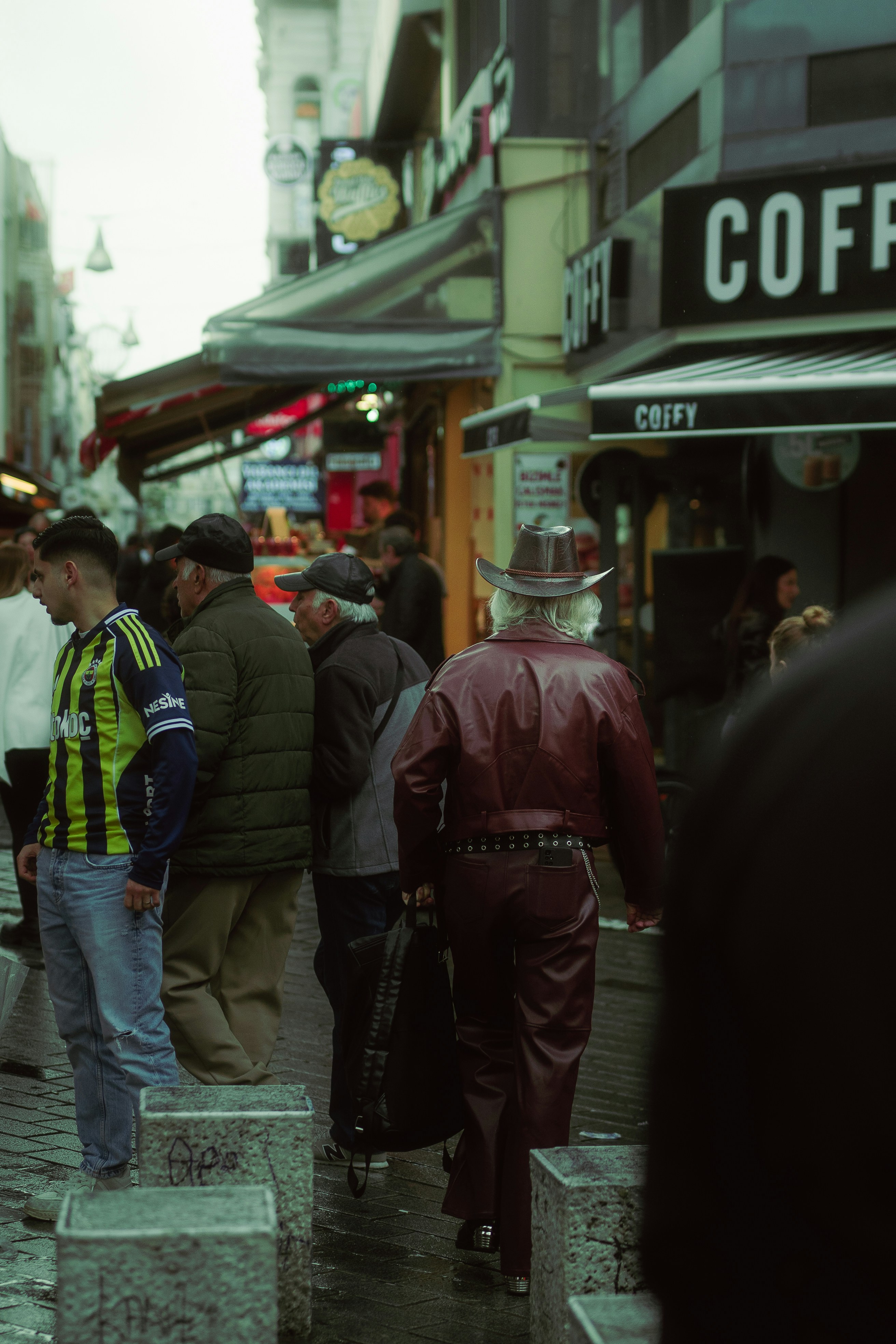 Man in cowboy hat walks down city street