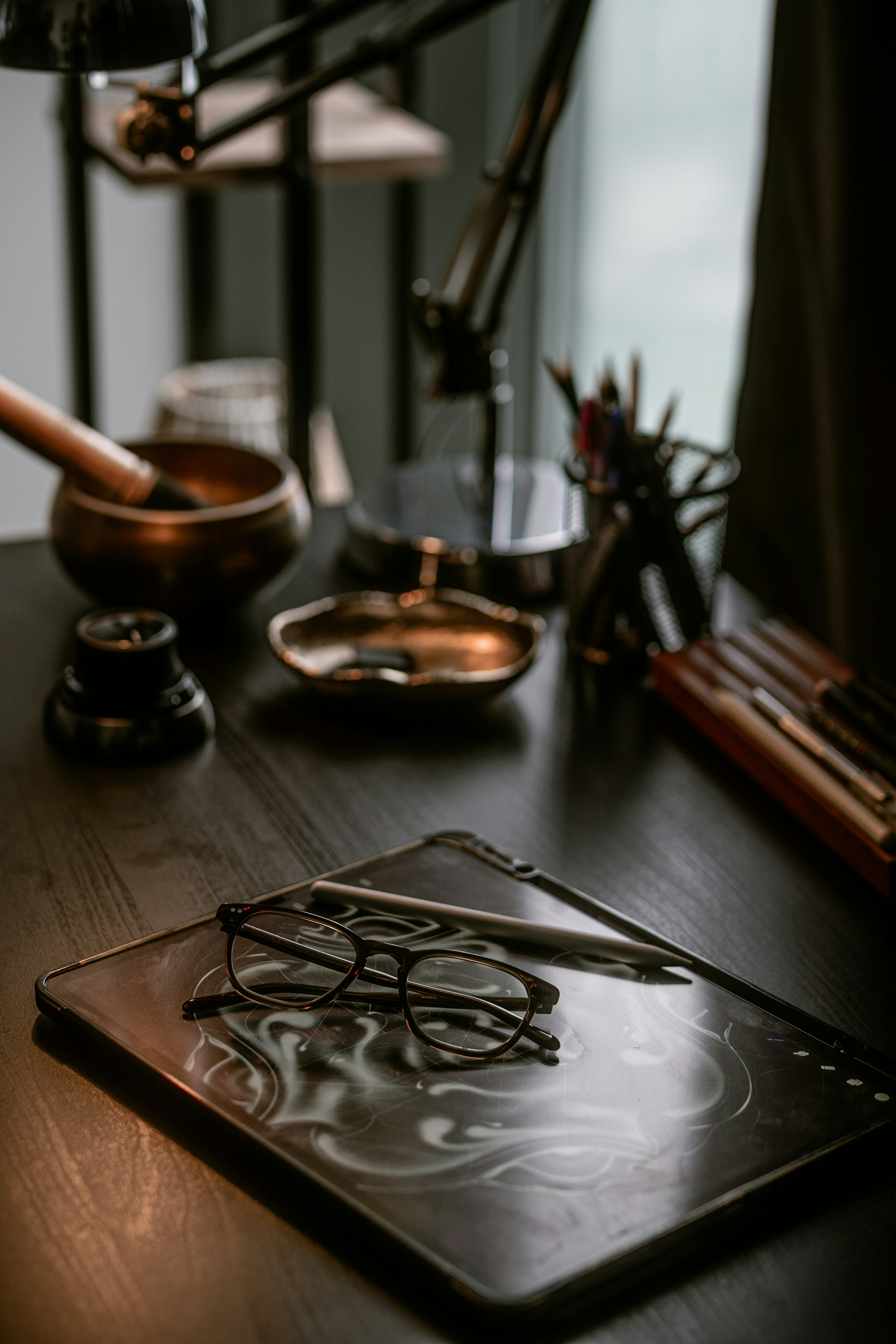 Glasses and stylus on a drawing tablet.