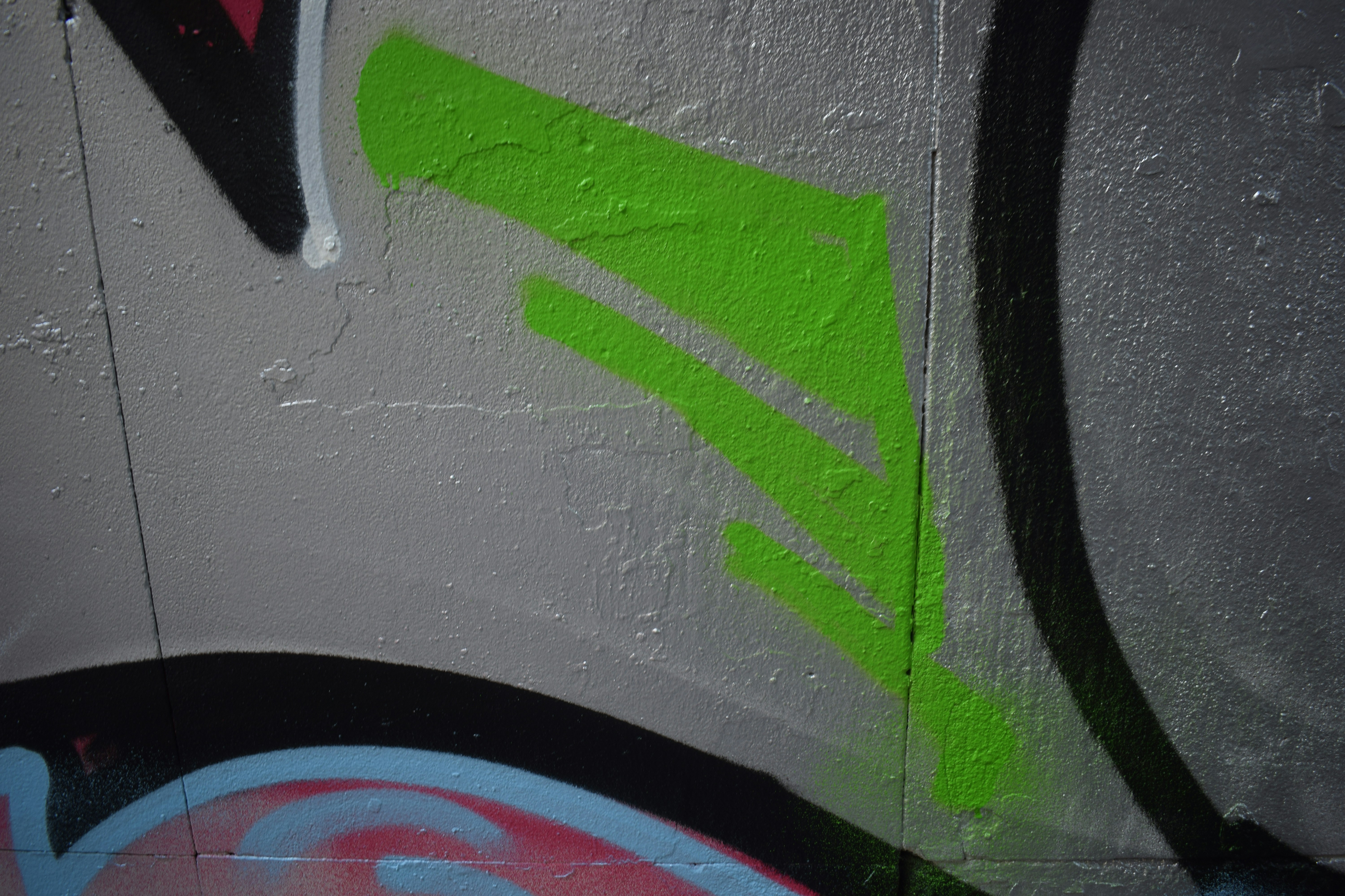 Bright green graffiti tags on a concrete wall