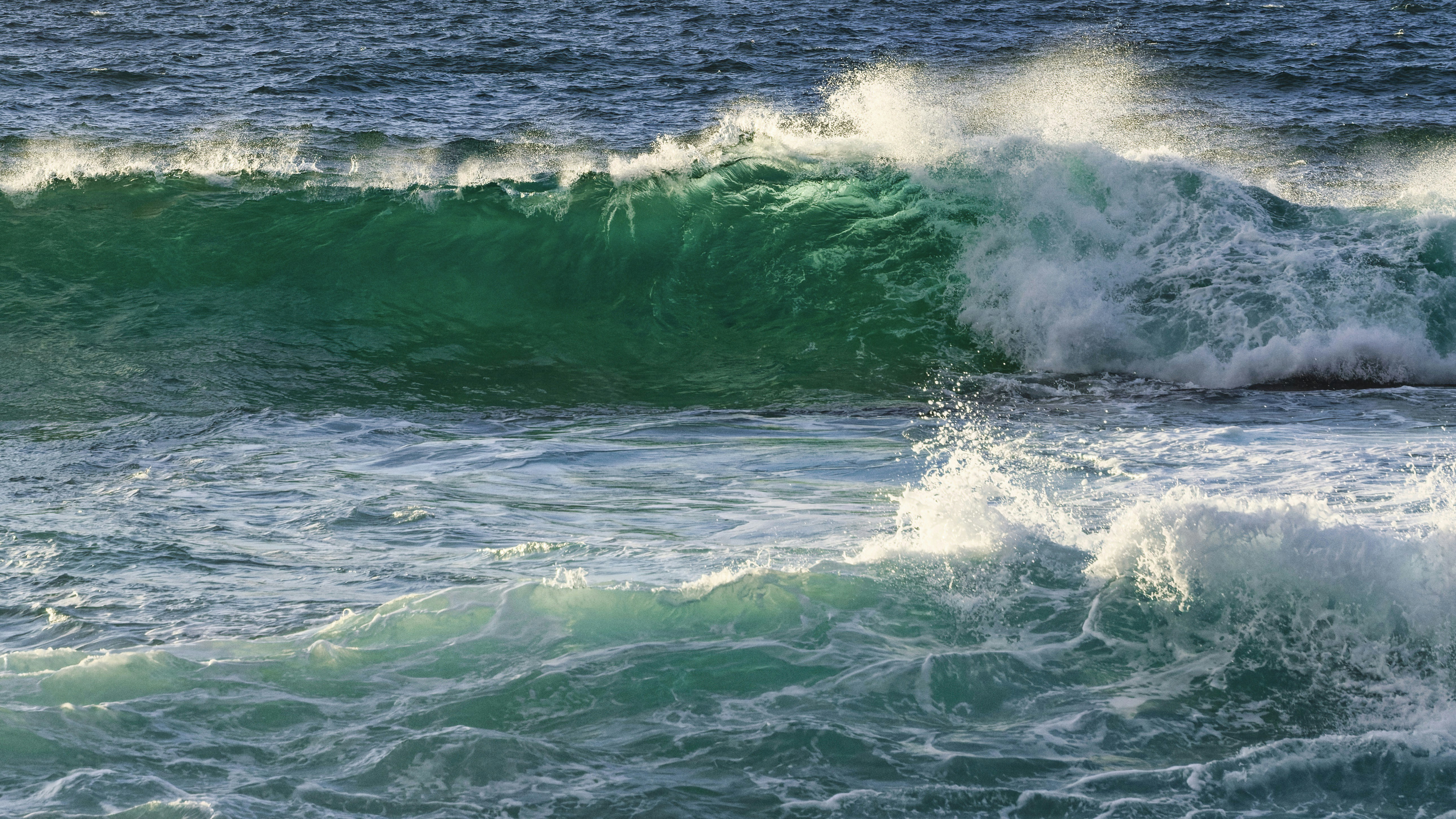 Turquoise waves crash onto a rocky shore