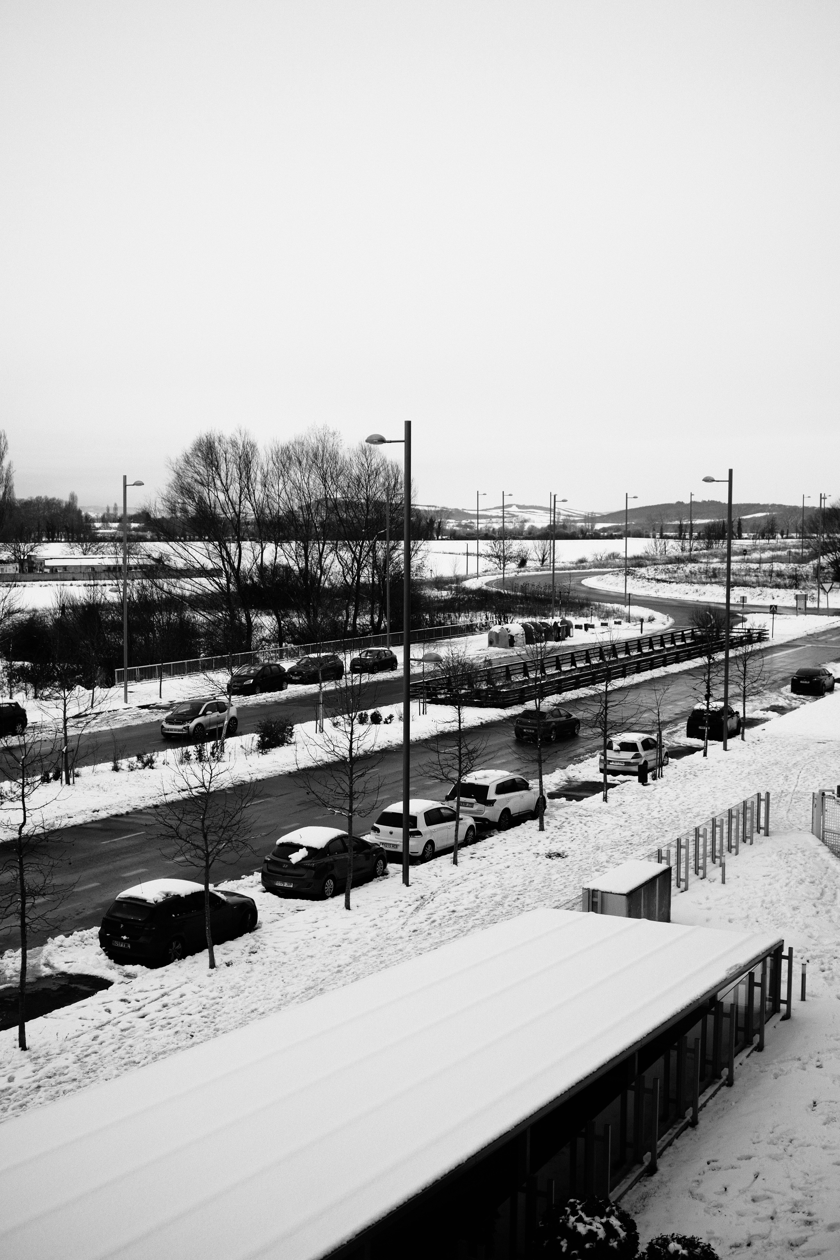 Coches aparcados junto a una carretera nevada en invierno.