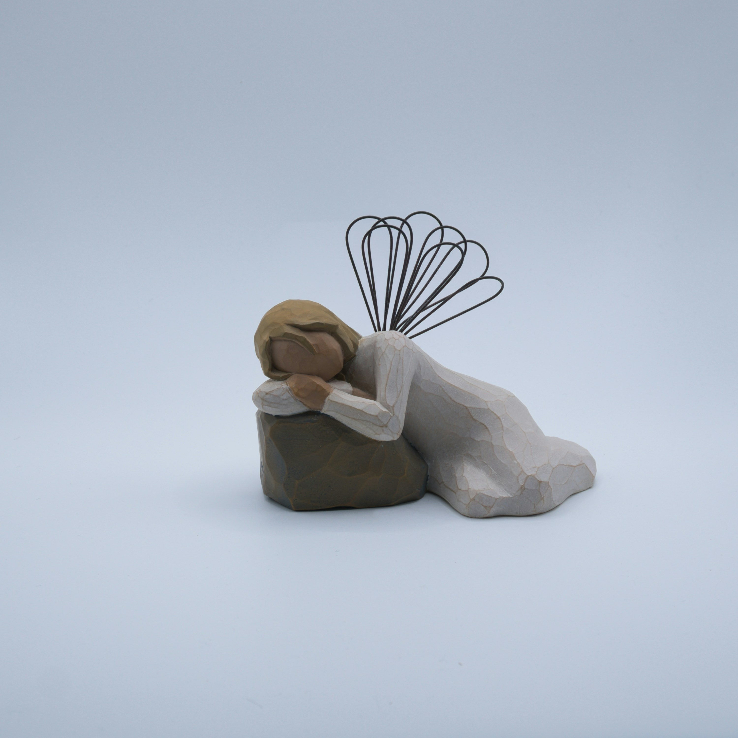 Angel figurine resting on a rock