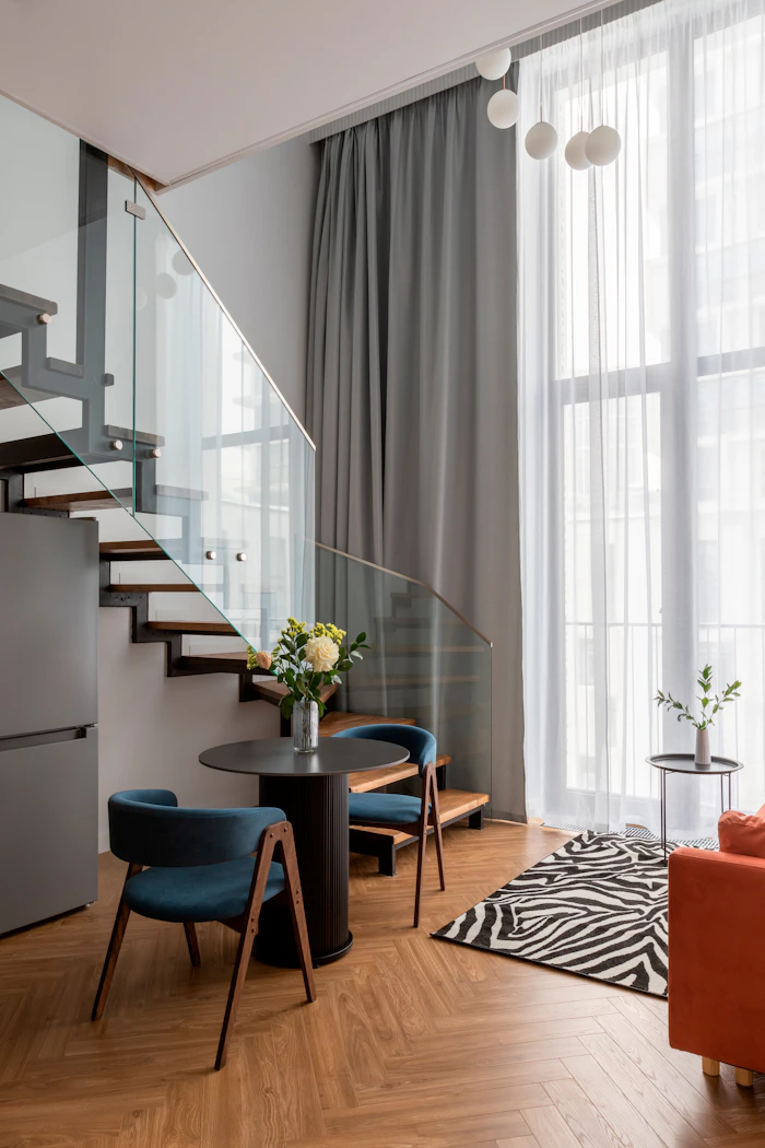 Bright modern living room with a glass staircase, the kind of interior a real estate photographer shoots | ProShoot.io