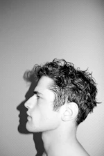 Profile of a young man with curly hair.