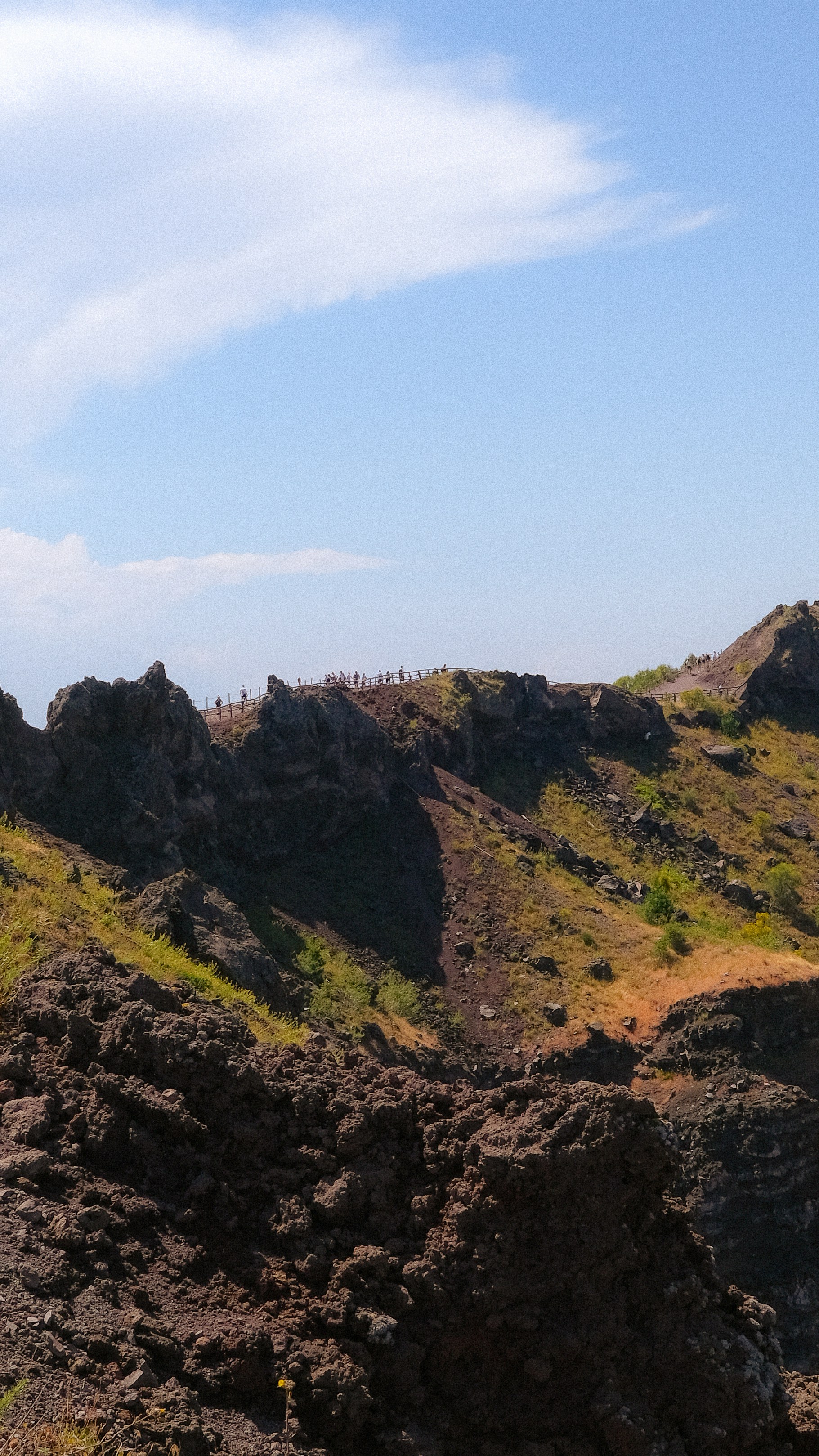 岩だらけの火山地形と縁に人がいる