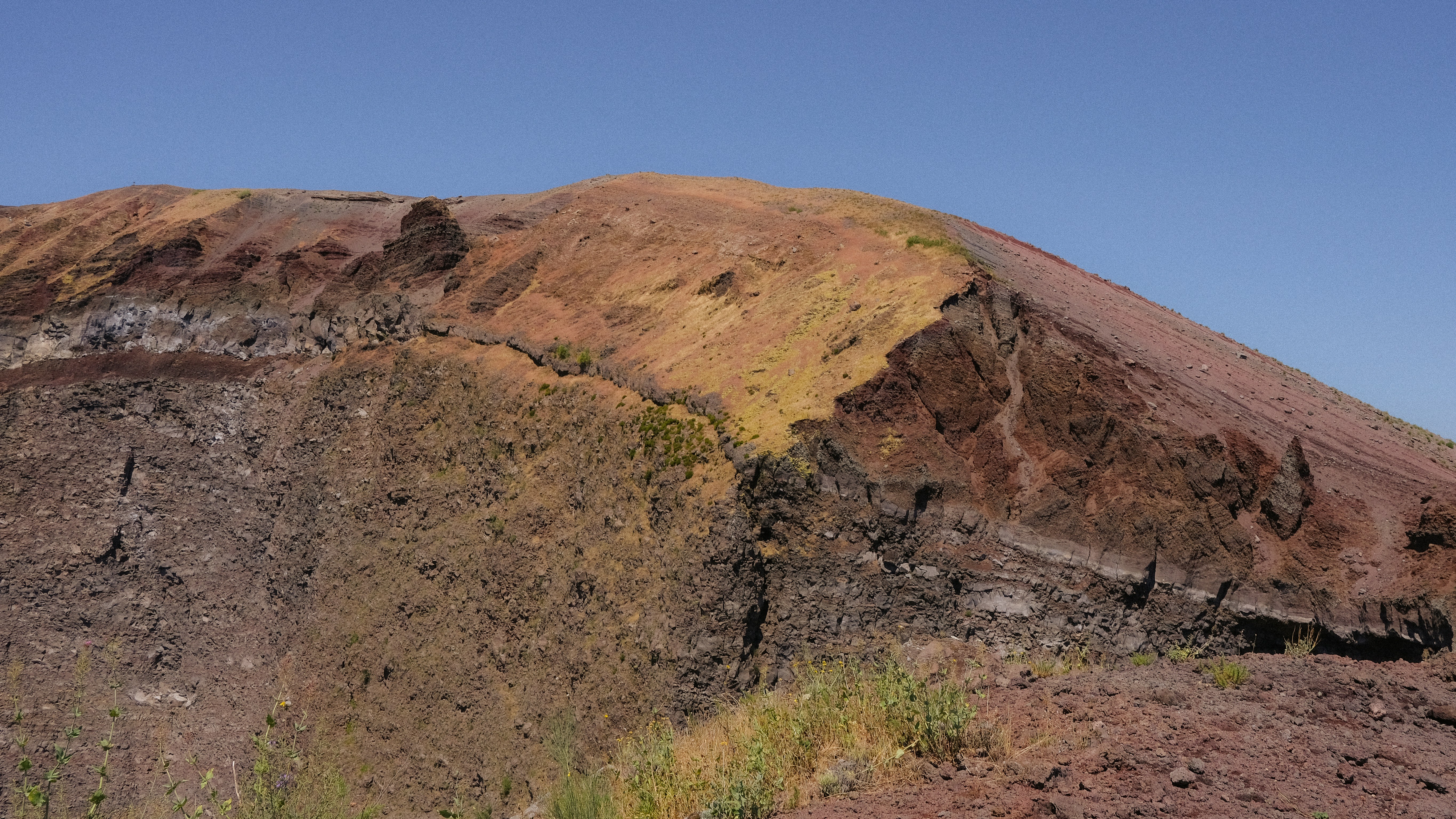 澄んだ青空の下、色鮮やかな火山の斜面。