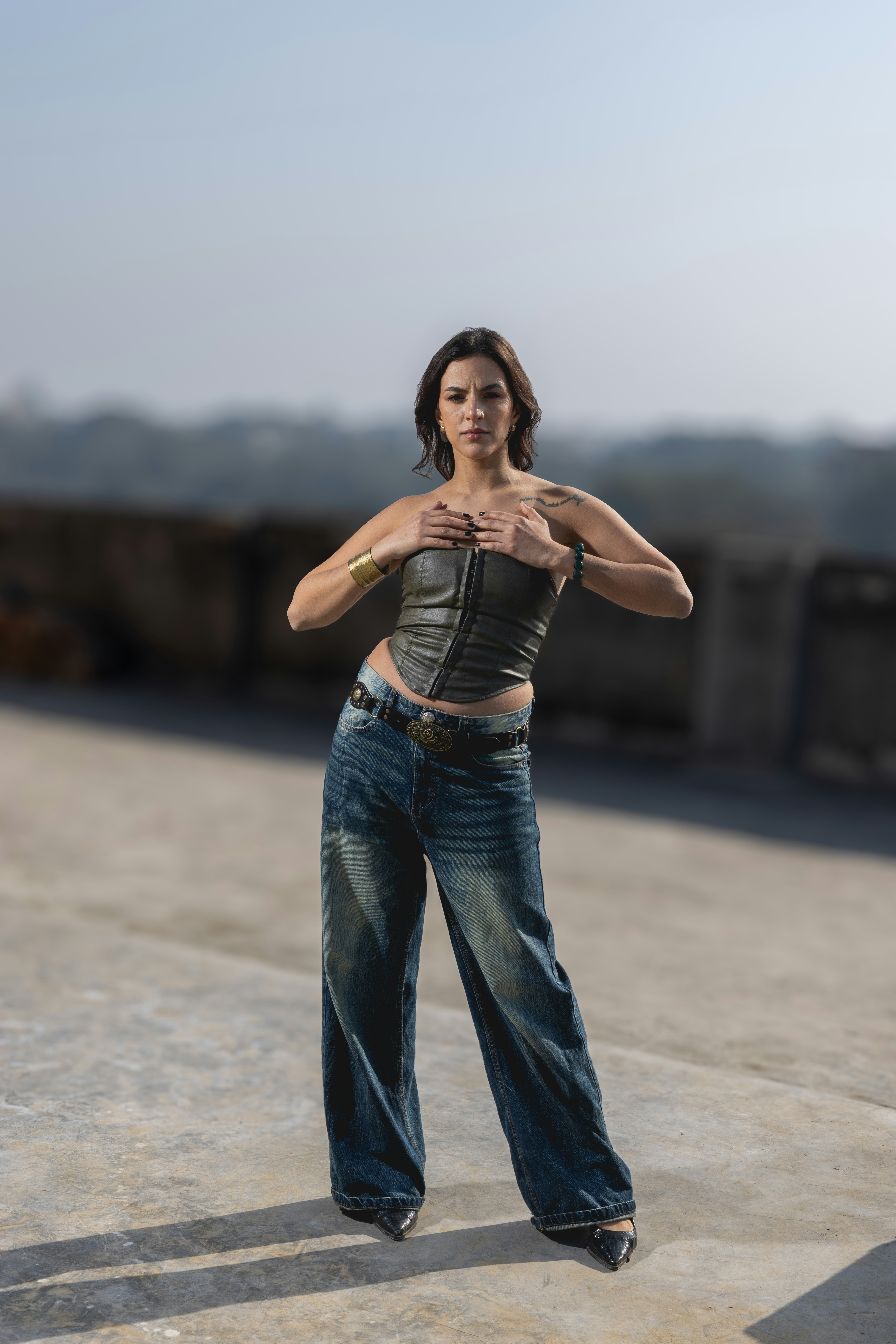 Mujer con corsé y vaqueros en la azotea