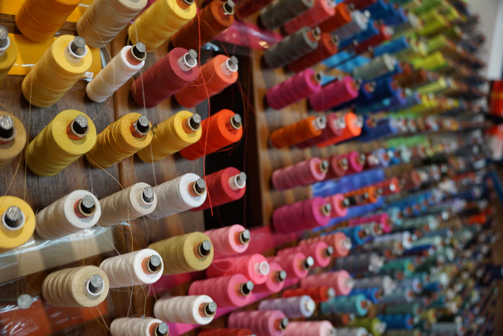 Workshop wall stocked with spools of thread in dozens of colours