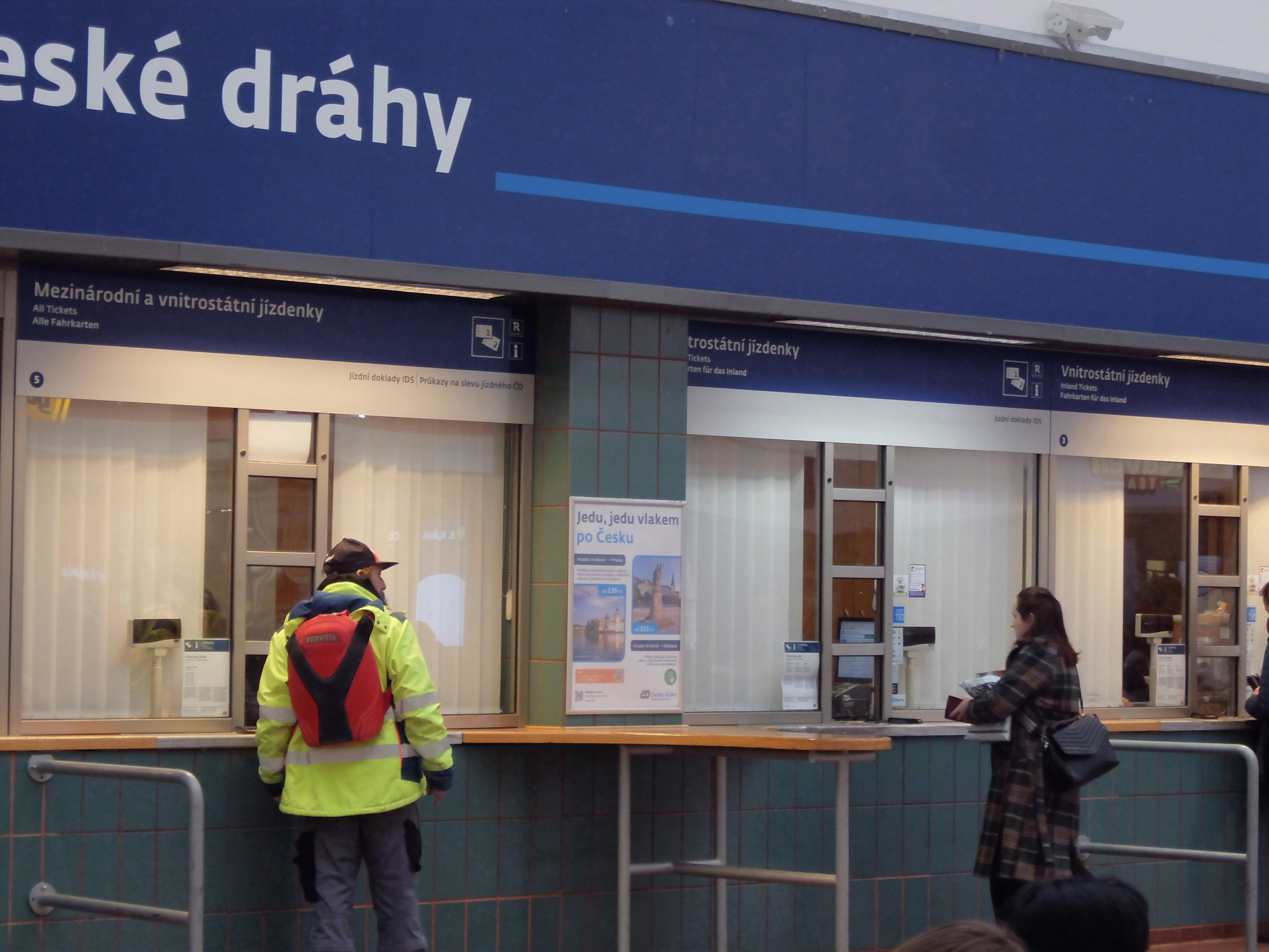 People at a train station ticket counter