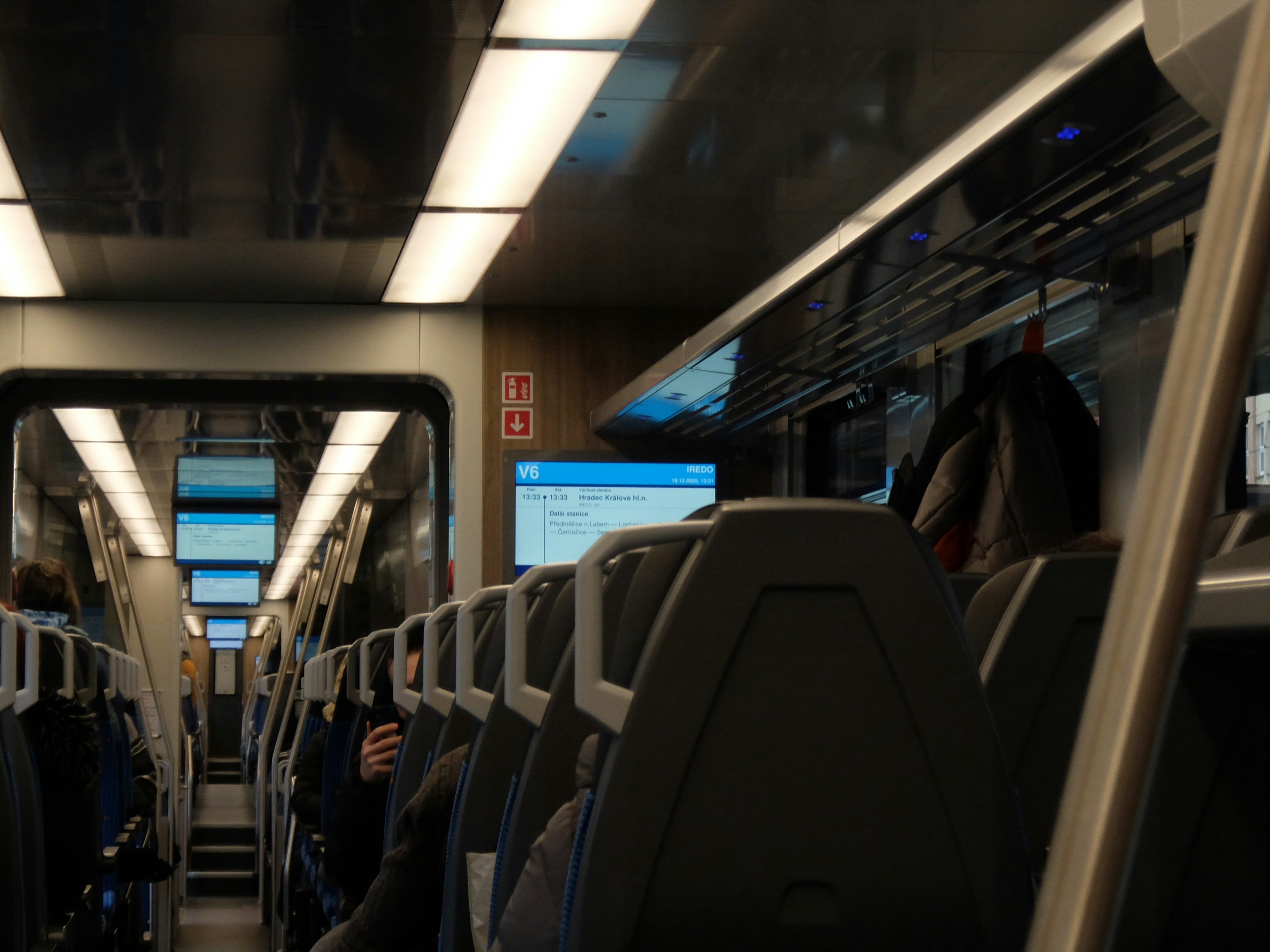 Interior view of a modern train carriage with seats.