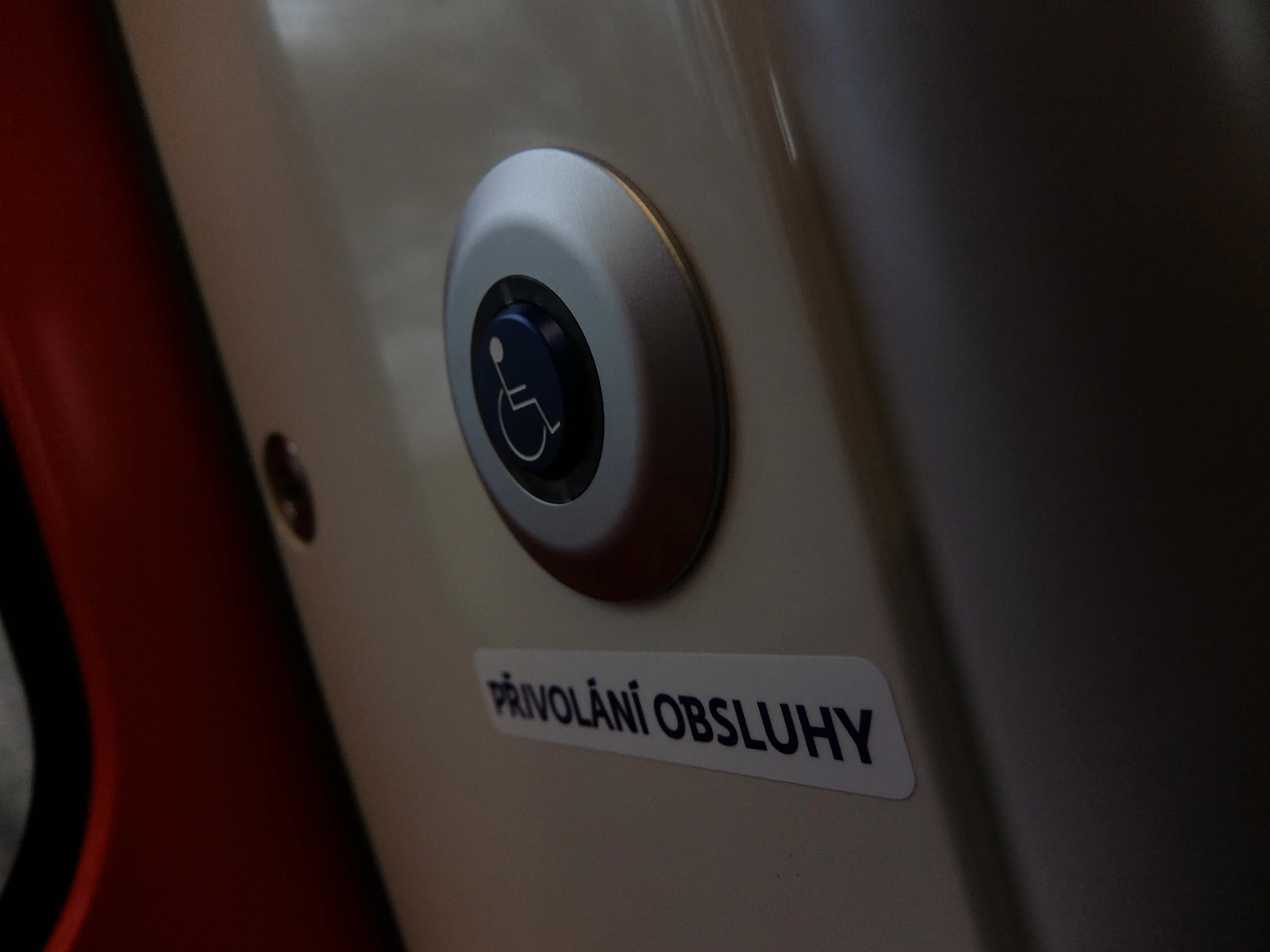 A blue wheelchair-accessibility button inside a public transport vehicle.