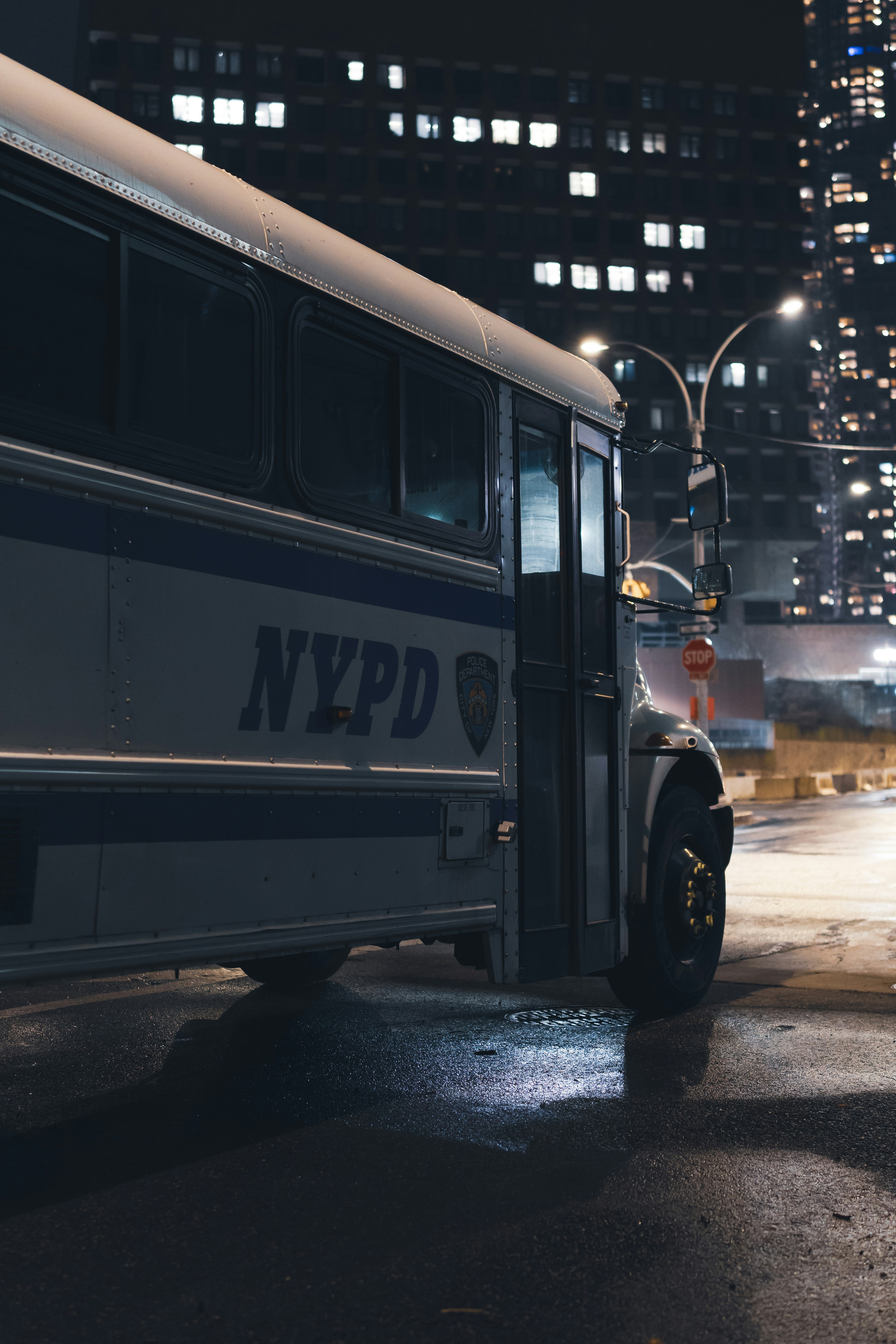 Bus du NYPD garé dans une rue humide de la ville la nuit