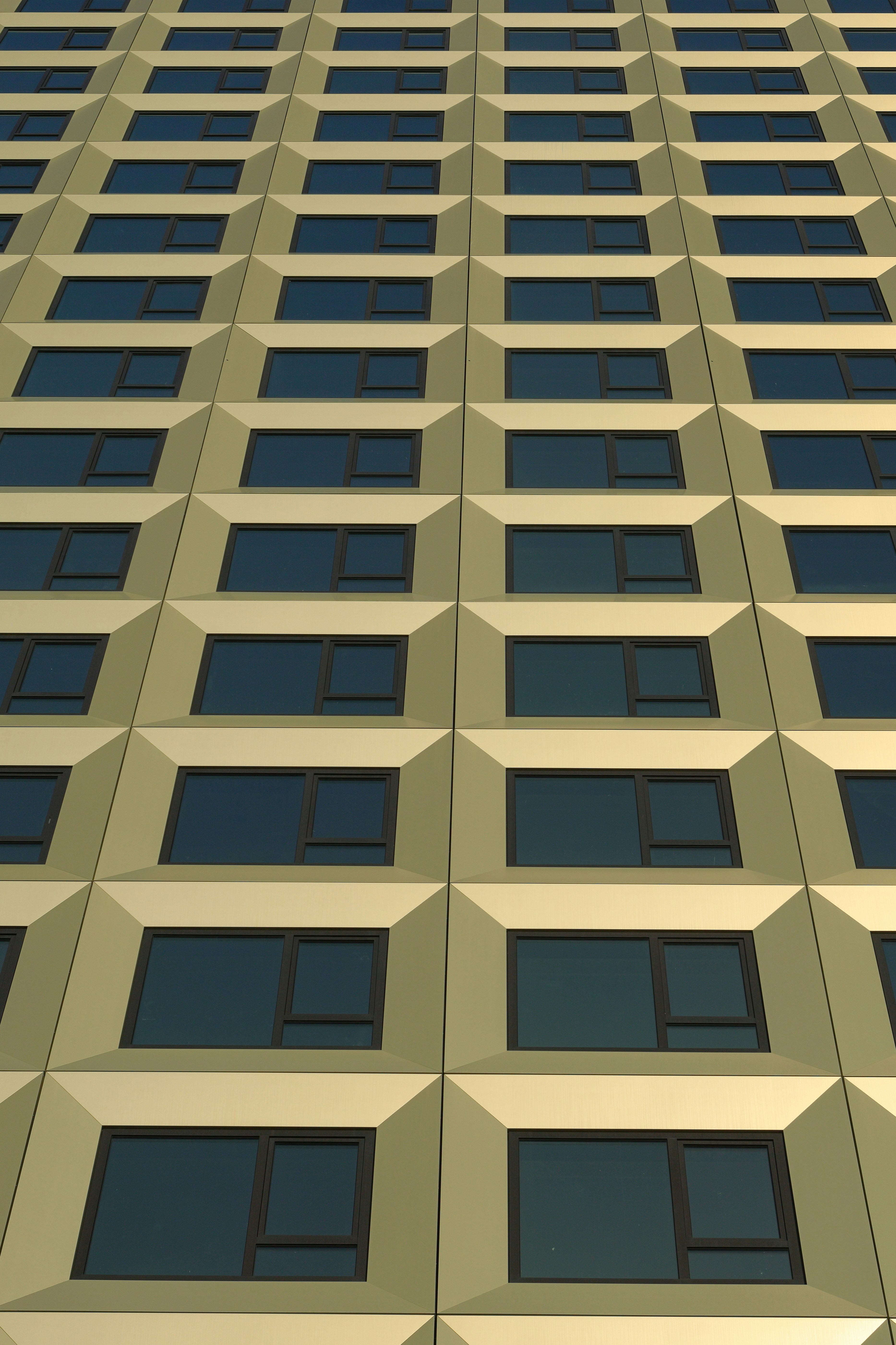 Fachada moderna de edifício com padrões repetitivos de janelas