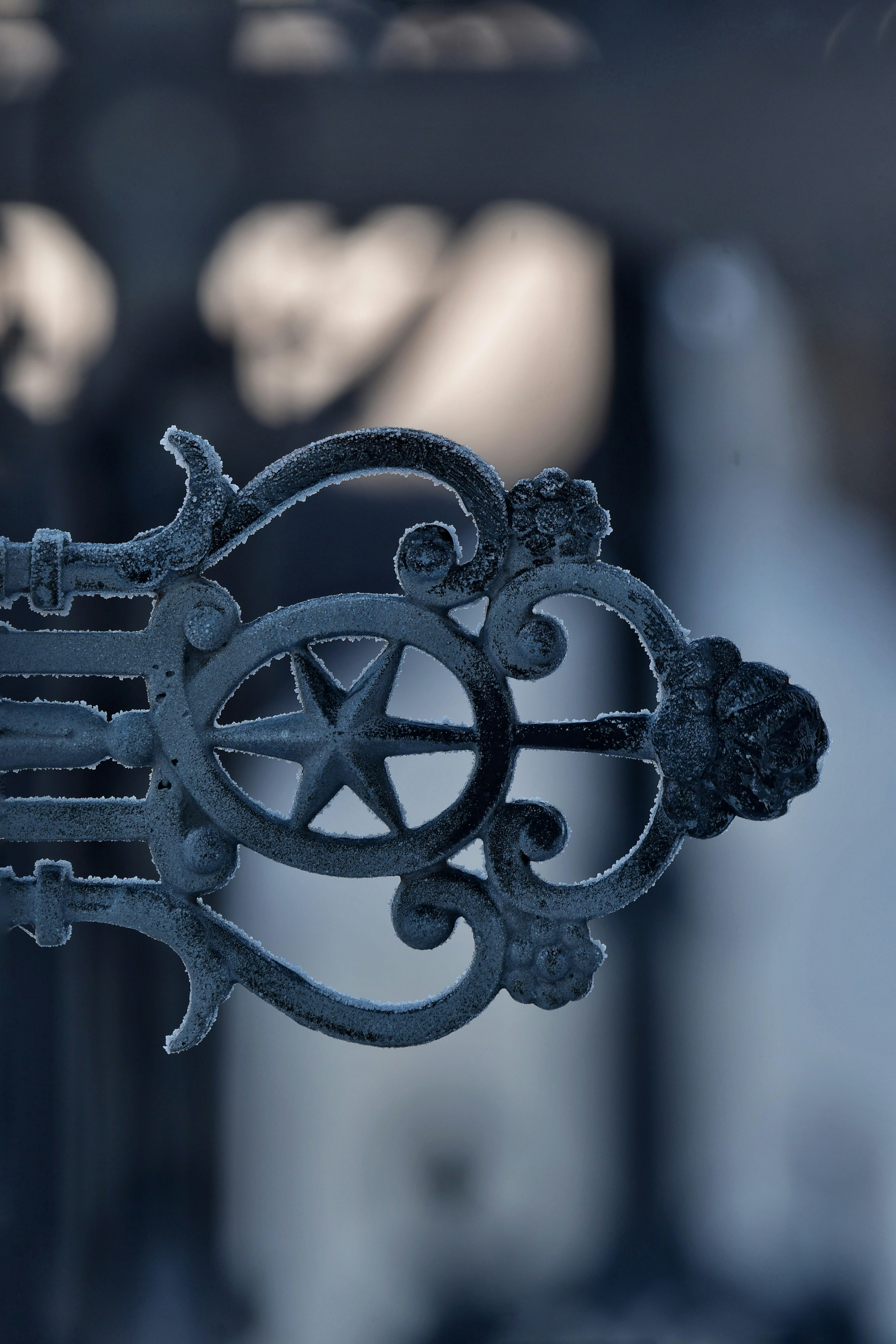 Ornate metal scrollwork with star detail covered in frost.