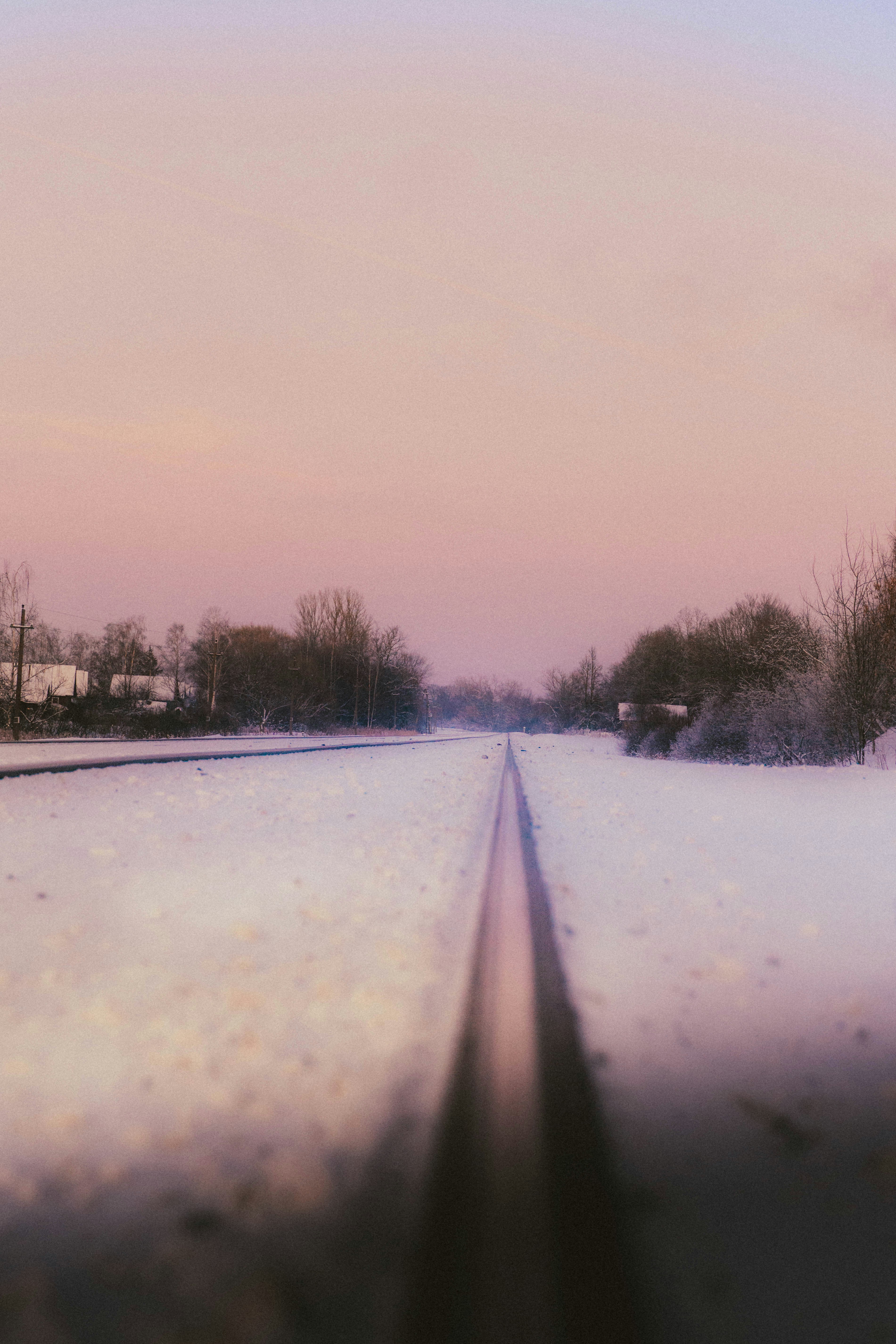 Snowy train tracks leading into the distance at dusk