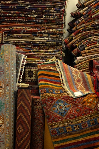 Stacks of colorful woven carpets and rugs in a shop.