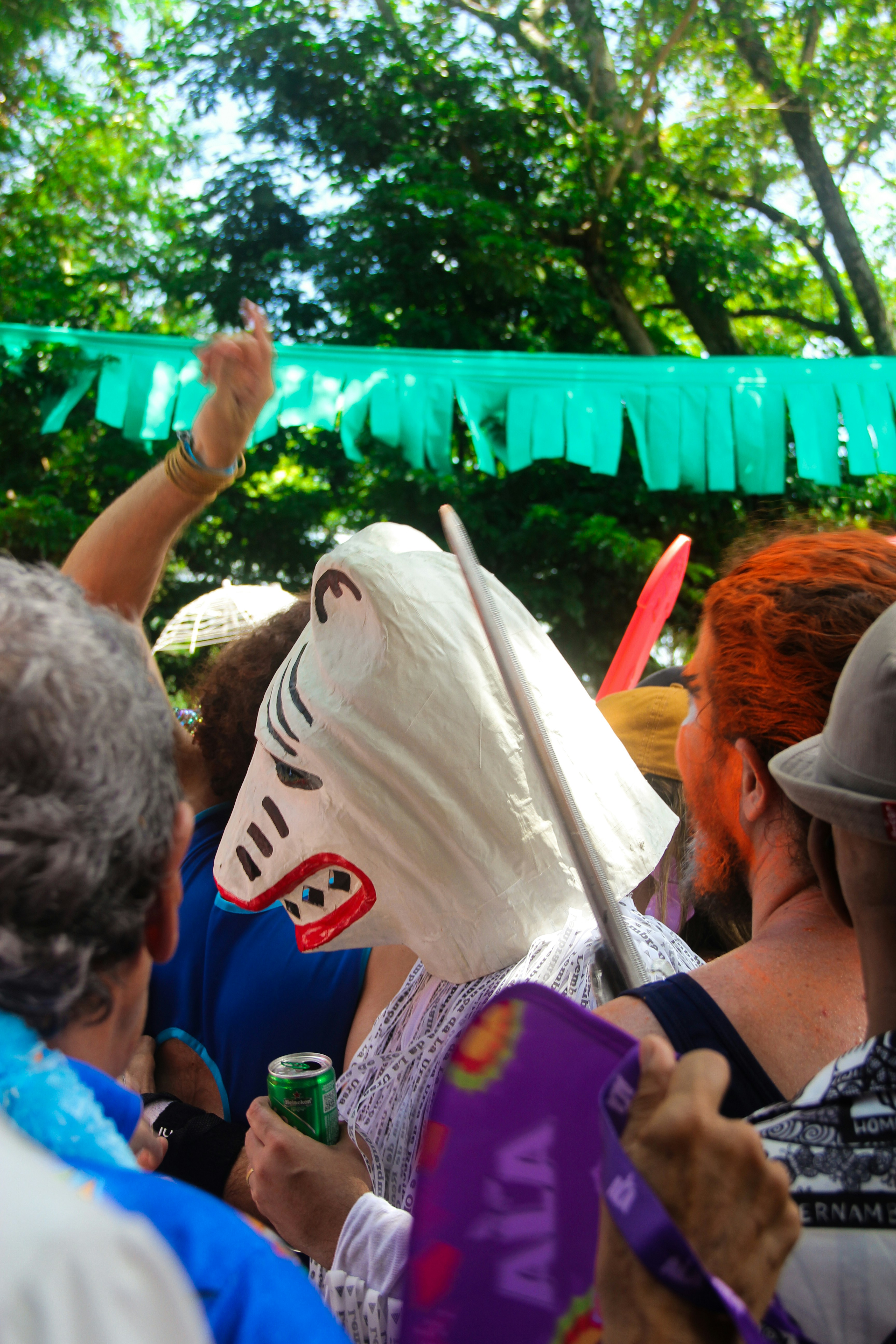 People in costumes at a festival with green banner