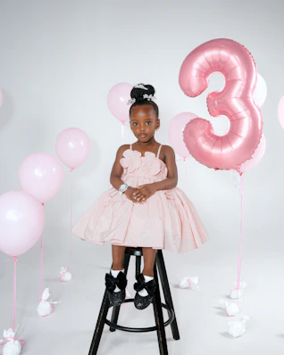 Young girl in a pink dress with balloons