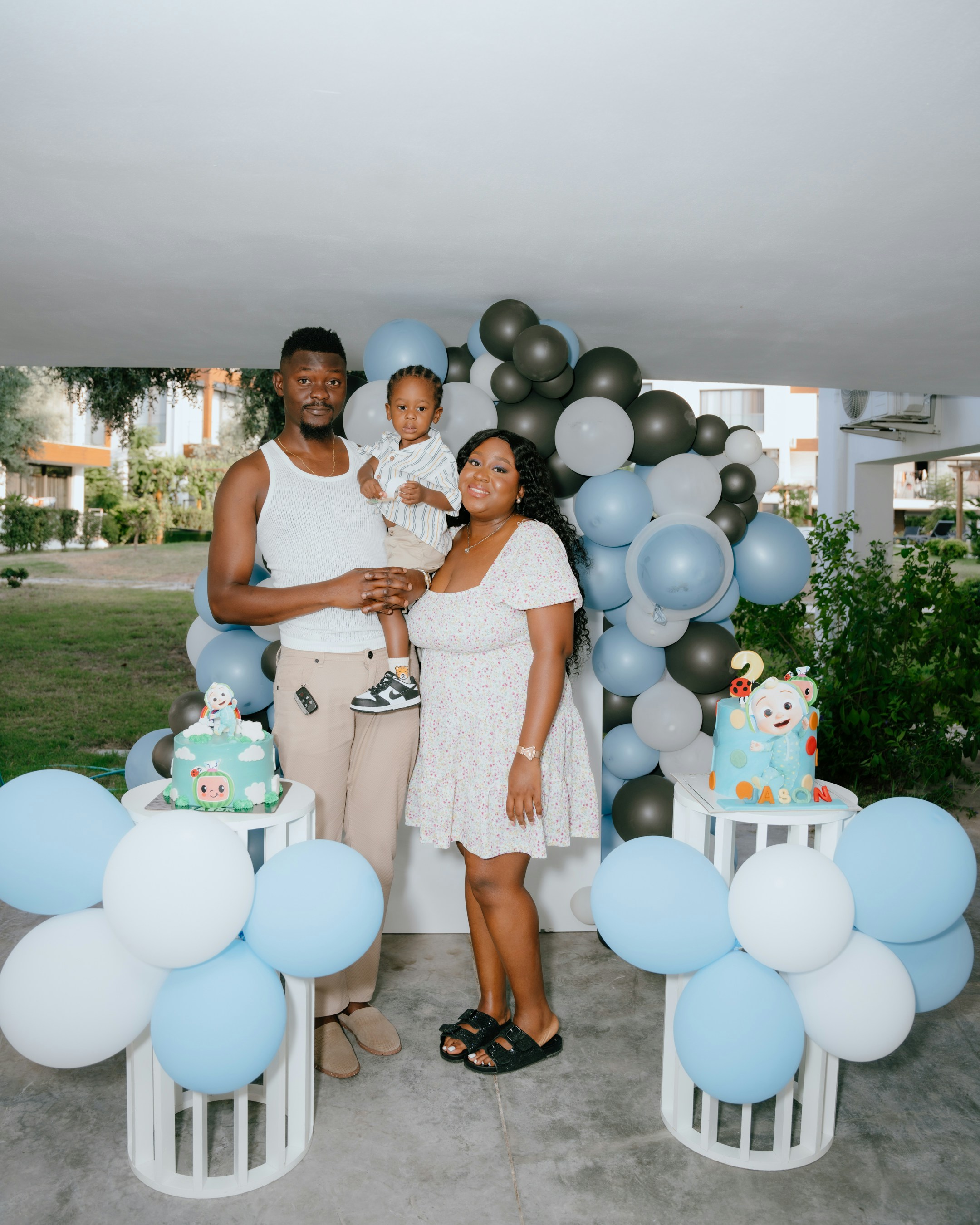 Familie feiert den zweiten Geburtstag eines Kindes mit Luftballons und Kuchen