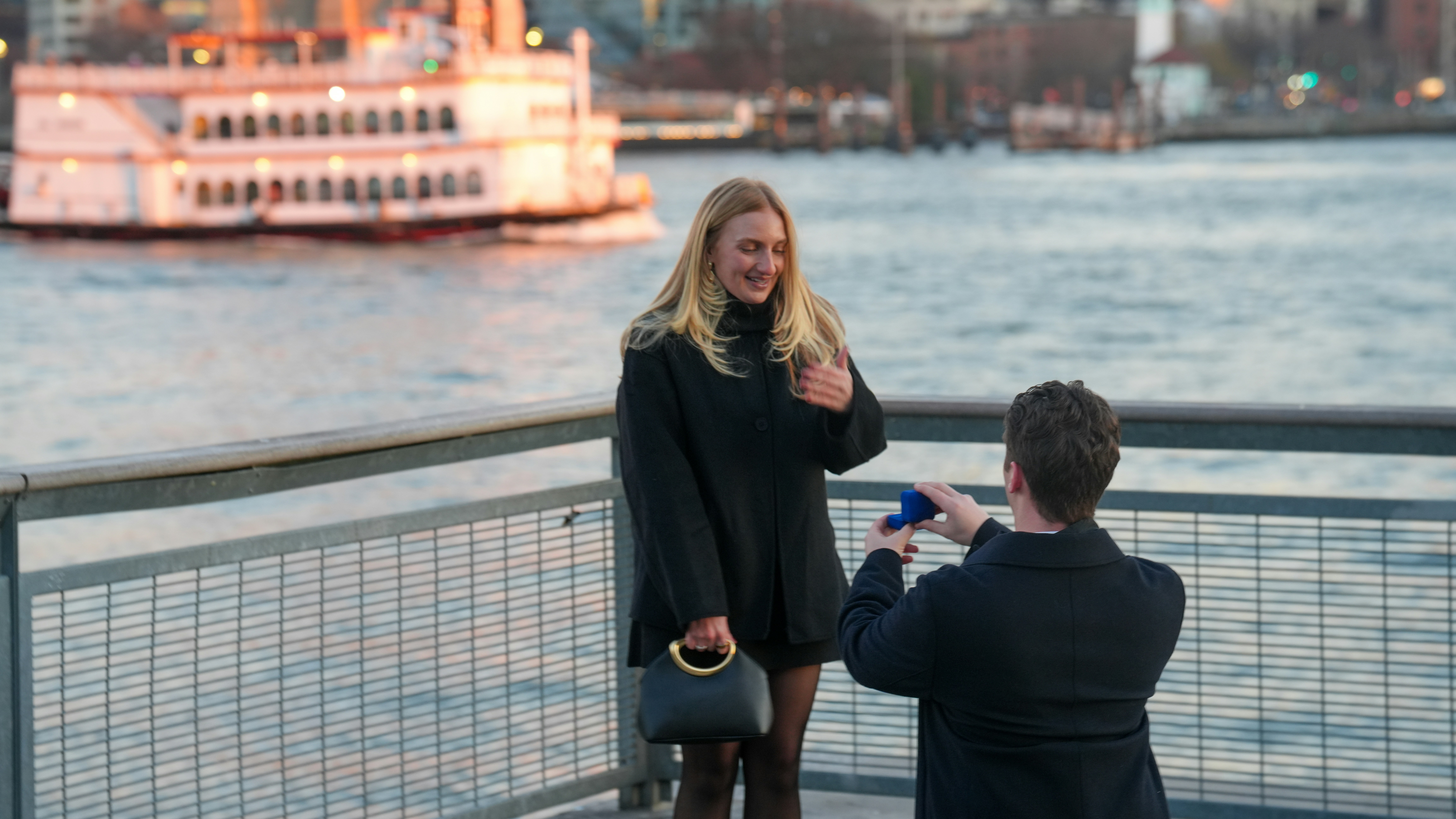 Man proposes to woman by river with boat