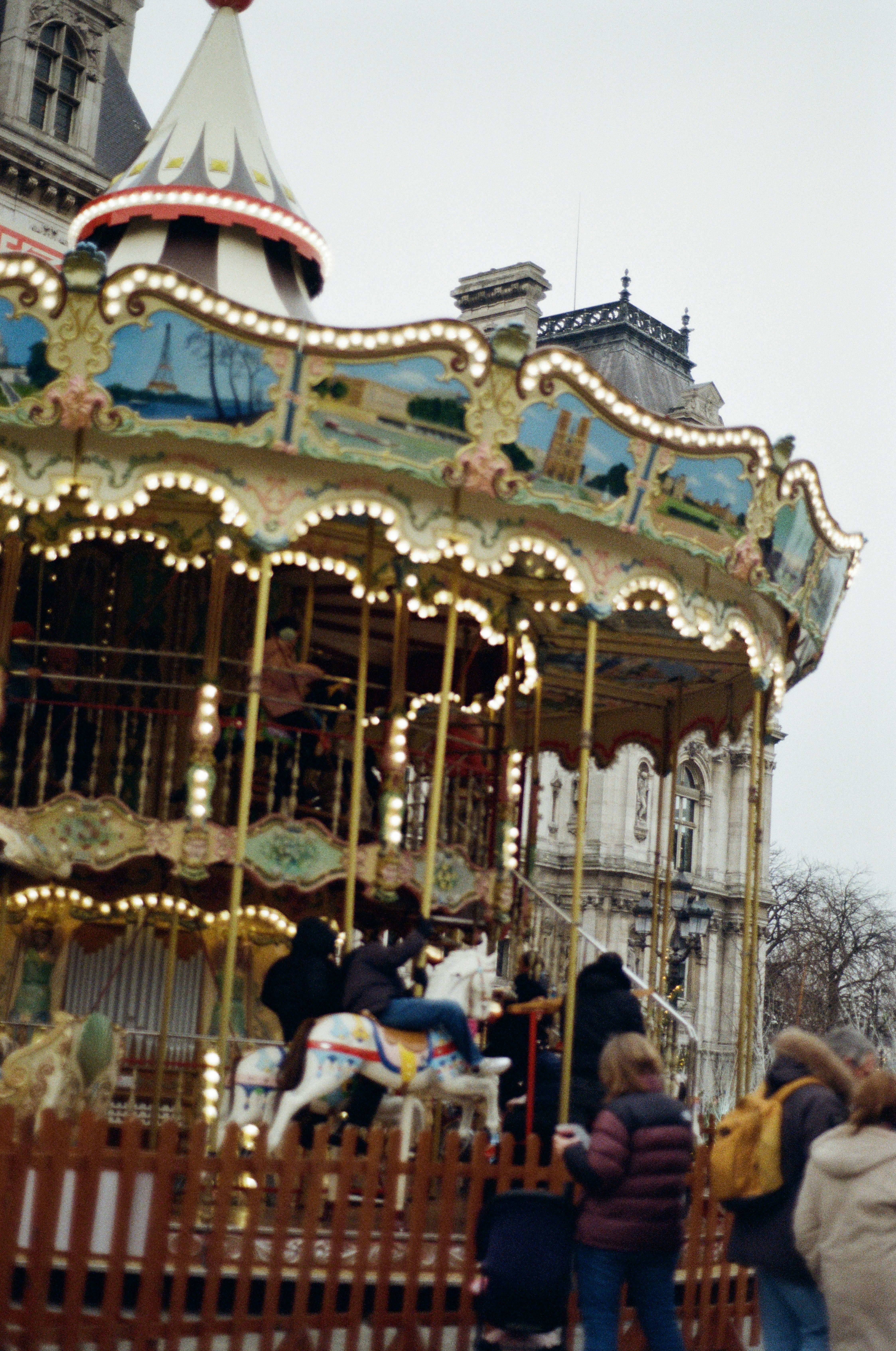 People riding a carousel in a city square