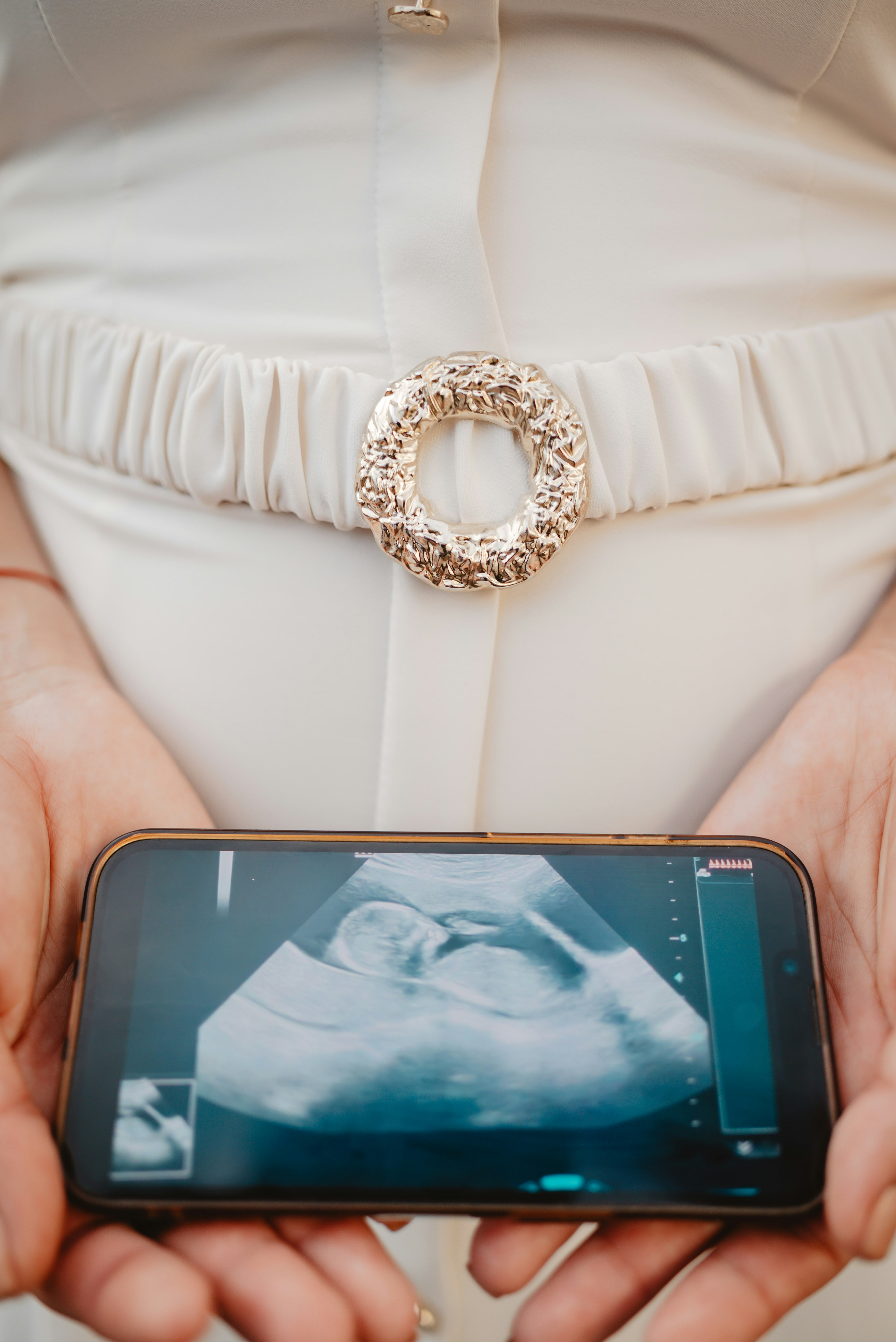 Woman holds phone displaying ultrasound of baby