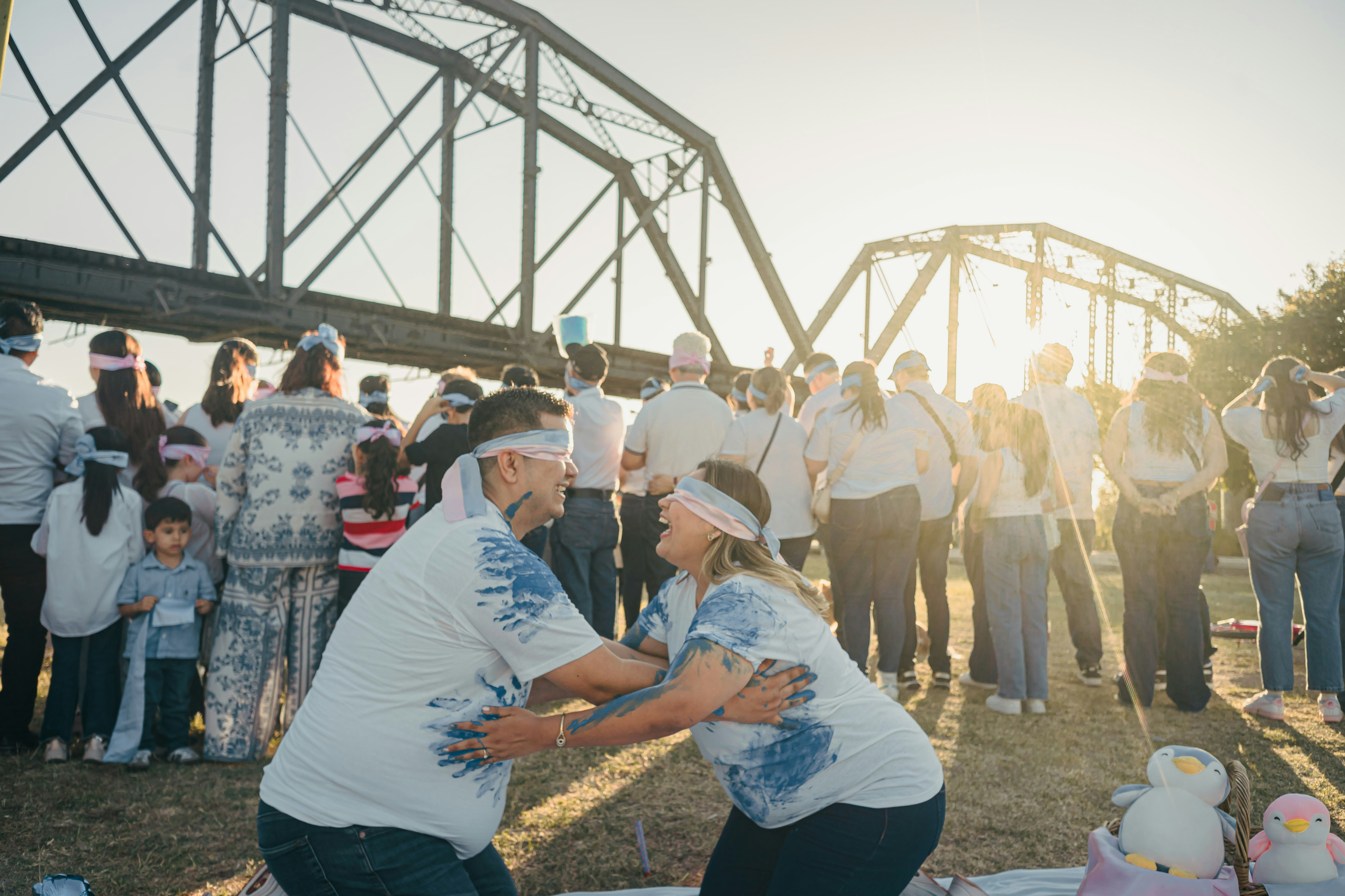 Couple plays a game with blindfolds near a bridge.