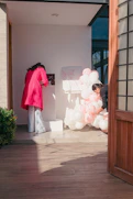 Two women decorating with pink and white balloons.