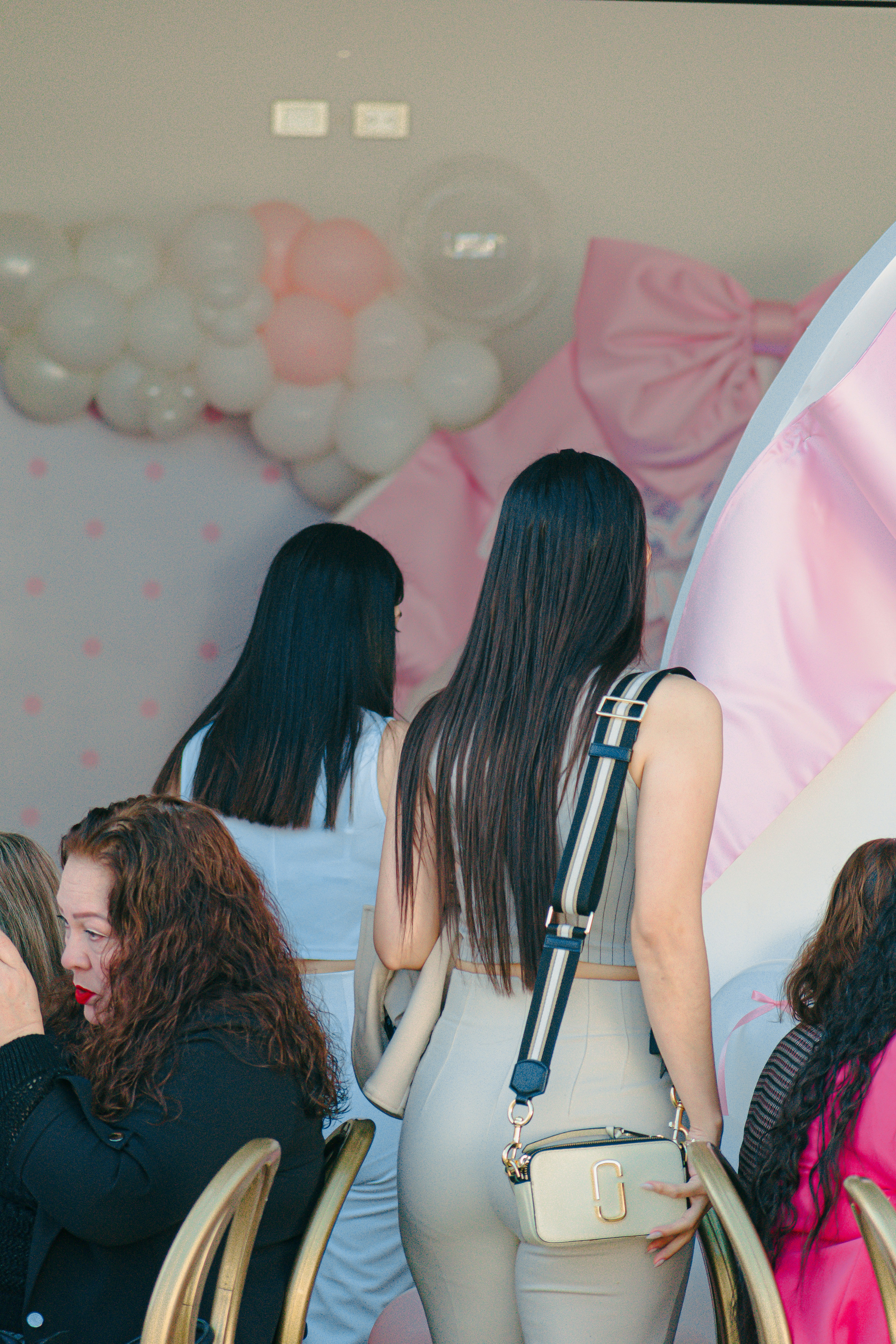 Women at a party with pink decorations