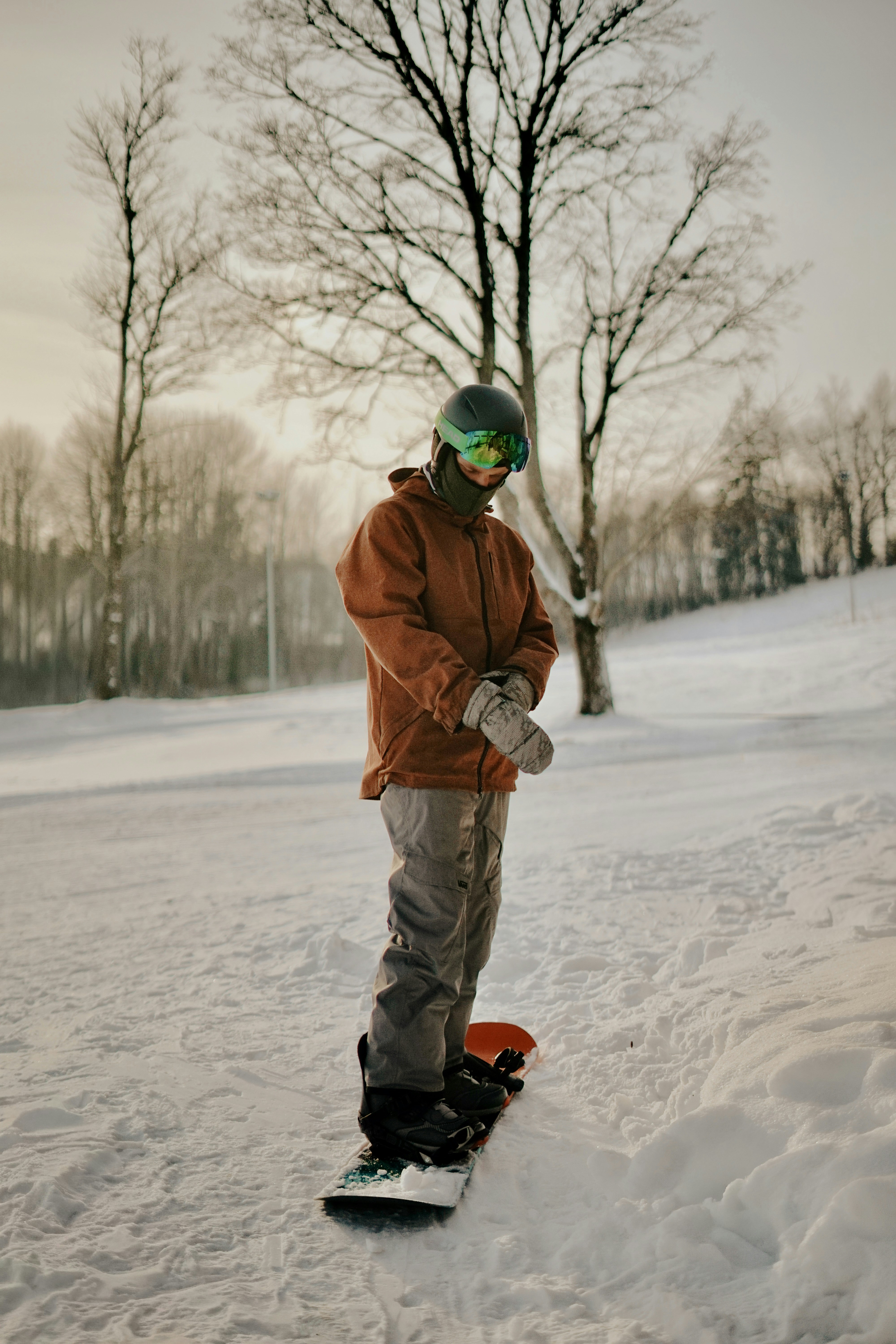 A snowboarder in winter gear on a snowy slope.